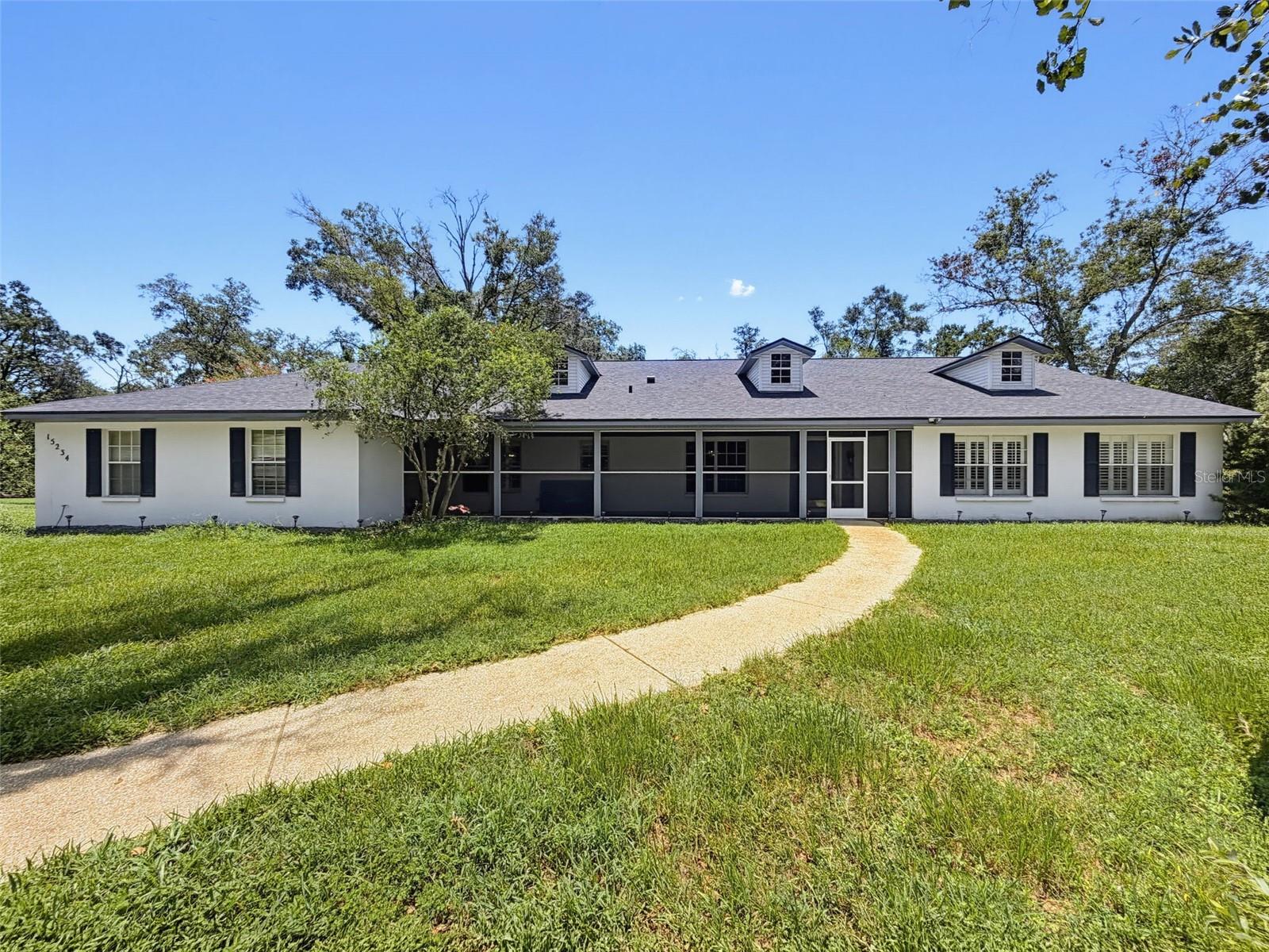 Escape the hustle and bustle of city life and discover the tranquility of this private 7.5-acre estate, offering the perfect blend of peaceful country living and everyday convenience. Tucked away in a serene setting within a gated community, this unique property features its own private gated entrance and provides endless possibilities for multigenerational living, equestrian enthusiasts, hobby farmers, or anyone seeking room to roam. The home features 6 bedrooms, 3 bathrooms, 4,026 sq ft, and an attached in-law suite with its own separate living area, providing exceptional flexibility for extended family or guests. The roof was replaced in 2022, adding peace of mind for the new owner. A circular driveway provides ample parking for family and guests. Step outside to enjoy the screened-in pool overlooking the beautifully landscaped grounds. The fully fenced property is enhanced by mature landscaping, beautiful Azelas, a charming front patio, and a picturesque bridge that creates a welcoming entrance. Additional property features include a detached metal garage, an outdoor storage shed, a chicken coop, two rear carports, a barn with two automatic waterers and electricity, and a music room that could be used as a home office, art studio, or workshop. RV owners will appreciate the 30-amp and 50-amp power hookups, while the two seasonal ponds add to the property's natural beauty and peaceful setting. Whether you're looking for a private family retreat, an equestrian property, or the ideal place to create your own homestead, this exceptional estate offers a rare opportunity to enjoy space, privacy, and endless potential—all within easy reach of shopping, dining, schools, and major roadways. Schedule your showing today!