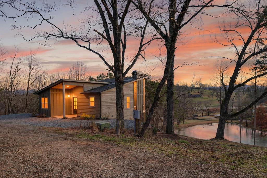 Stunning brand-new custom contemporary home showcasing year-round mountain views. This three-bedroom, three-and-a-half-bath residence features an open-concept main level with seamless flow between the living room, dining area, and kitchen, complete with beautiful custom cabinetry, stainless steel appliances, and a stacked-stone gas log fireplace. Luxury vinyl flooring runs throughout the home, offering both style and durability. The spacious primary suite is conveniently located on the main level. Step outside to the inviting main-level deck with its own fireplace, overlooking a tranquil pond—perfect for year-round enjoyment. The fully finished terrace level provides exceptional additional living space and includes a wet bar, ideal for entertaining, large great room and two master ensuites. From the terrace level, step outside to a fire pit area overlooking the views, creating an ideal setting for relaxing or gathering with guests. The property has plenty of space for a garage or carport. An adjoining lot is also available for purchase, offering added privacy or expansion potential. Conveniently located just minutes from lake access for boating, as well as restaurants, shopping and medical facilities. Call me today!