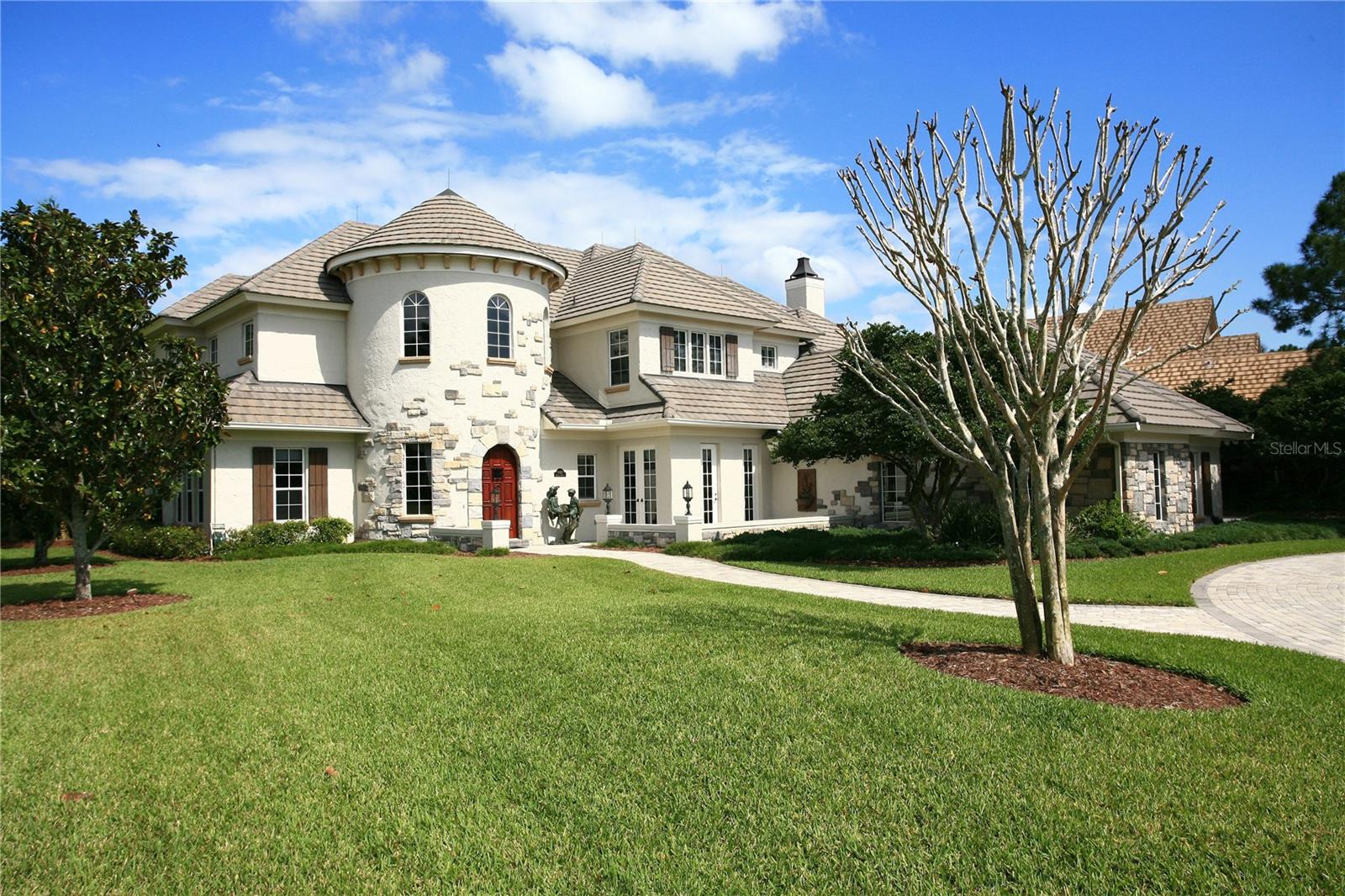 The stunning exterior façade of this exquisite French country home commands your attention with its two-story tower entry.  Situated on a .66-acre homesite, the magnificent aesthetic appeal is simply breathtaking.Enter through a custom, carved mahogany door into the grand foyer with a stunning spiral staircase and the eye is immediately drawn up to the Florida cypress tray ceiling with mural.  Open, sun-filled living spaces include a two-story family room with fireplace, dining room with hand-painted Monet mural replica and a wine cellar complete with iron entry and stone flooring.  A spectacular chef’s kitchen with breakfast room overlooks the spacious lanai complete with heated spa and stone waterfall.Additional features include:      • Master Suite with separate Lounge      • 1st and 2nd level Offices      • Screened lanai with summer kitchen and heated spa      • Oversized second-level Evening Deck w/ wet bar      • 3-Car Garage with Golf Cart Storage