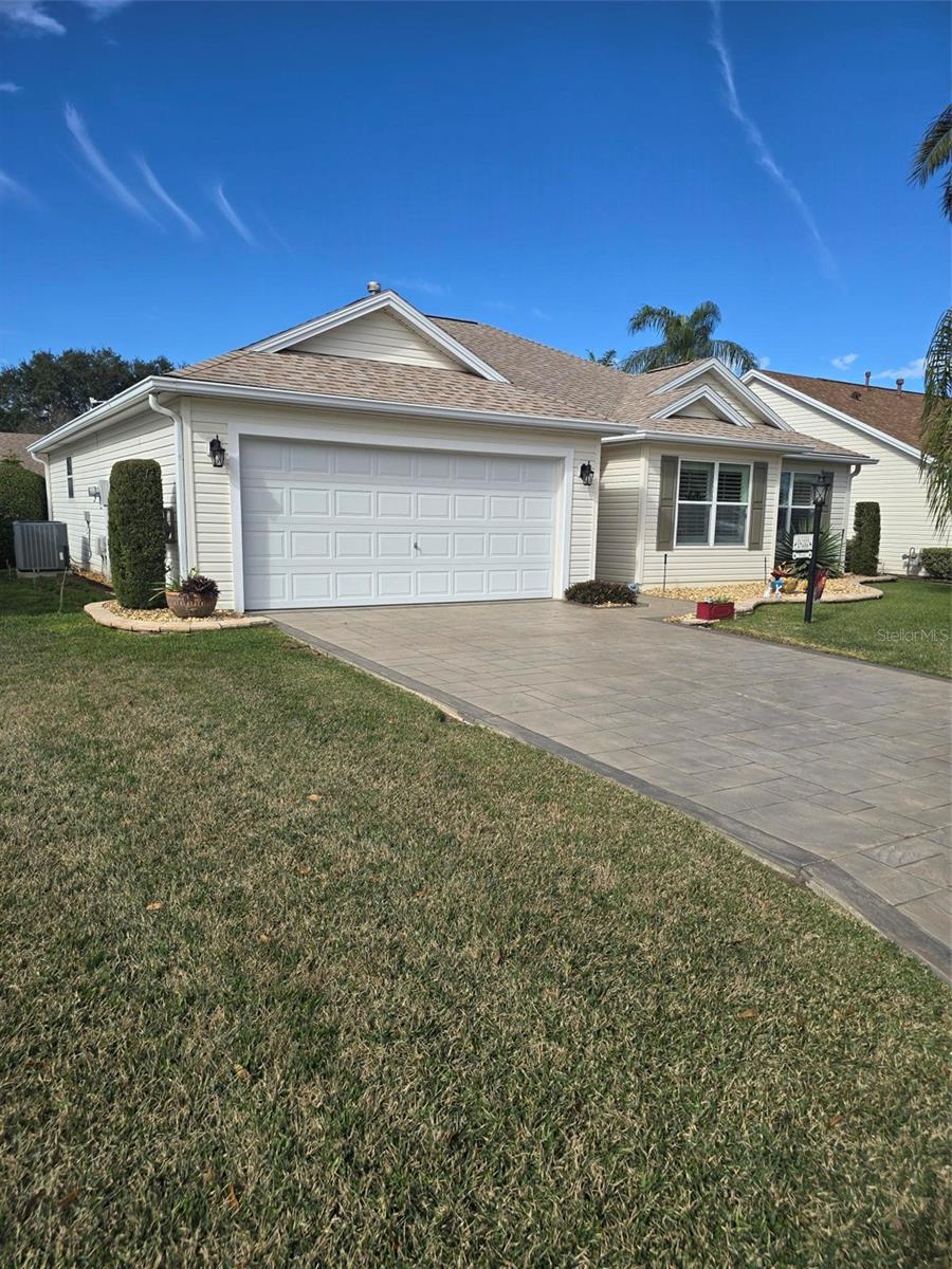 CHARMING 3/2 WHISPERING PINE DESIGNER in the VILLAGE OF PIEDMONT - convenient to Mulberry Grove shopping area and Nancy Lopez Country Club. LOVELY entrance with a stamped driveway and wonderful curb appeal with STACK ROCK walls, palms and shrubs. LAMINATE flooring (NO CARPET in this home) and CROWN MOLDING throughout. The spacious kitchen has HONEY OAK cabinets w/crown molding, hardware & pull-out drawers, GRANITE counter tops, TILE back splash, breakfast bar, large TILE flooring and a convenient casual dining area with lovely bay window. The updated STAINLESS appliances include a FRENCH DOOR refrigerator with bottom freezer, beautiful 5 burner GAS range, dishwasher and mounted microwave. The spacious living room has PLANTATION SHUTTERS covering the sliding glass doors that lead to your ENCLOSED lanai with TINTED  Windows and TILED flooring, a great place to sit and enjoy your morning coffee with privacy landscaping. A nice patio off the lanai is great for your grill. The master bedroom features a walk-in closet, vaulted ceiling, PLANTATION SHUTTERS and en-suite bath with GRANITE countertop w/DUAL SINKS and updated shower with FRAME-LESS GLASS DOORS. In the front of the home is your guest bedroom and guest bath with GRANITE countertop and tub/shower.  Double French doors open to the 3rd bedroom/den (no closet). A NEW ROOF was installed in October 2019; NEW HVAC 2017 and NEWER LG WASHER & DRYER! Other GREAT FEATURES: vaulted ceilings, décor colors, CROWN MOLDING THROUGHOUT, PLANTATION SHUTTERS on the windows and sliding glass doors, NO BOND and more!!. Great location to shopping, restaurants, pools and golf courses … all the amenities of The Villages!  GOLF CART is Negotiable.