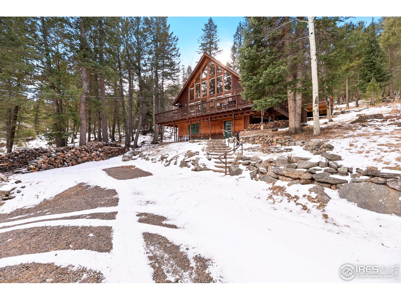 Escape to your own private mountain haven at 1655 Black Squirrel. Nestled in the trees on nearly three secluded acres, this home offers the perfect blend of rustic charm and refined mountain living. The stunning great room anchors the home, featuring soaring tongue-and-groove ceilings, a stone fireplace, and a massive wall of windows that invites the outdoors in. Watch deer wander through the property and listen to the soothing sounds of the seasonal stream right from your living room. Boasting over 2,000 sq. ft. of living space, the home is designed for relaxation. The main level flows effortlessly onto an enlarged deck-perfect for a soak in the hot tub, summer entertaining, or stargazing in the crisp air. The finished lower level expands your options with a spacious gaming area and a private bedroom ideal for family or guests. Located just minutes from Estes Park and the entrance to Rocky Mountain National Park, you also enjoy direct access to the Roosevelt National Forest via the Pierson Park 4WD road. Experience true seclusion with quick access to miles of adventure. Come discover the sought-after Little Valley neighborhood.
