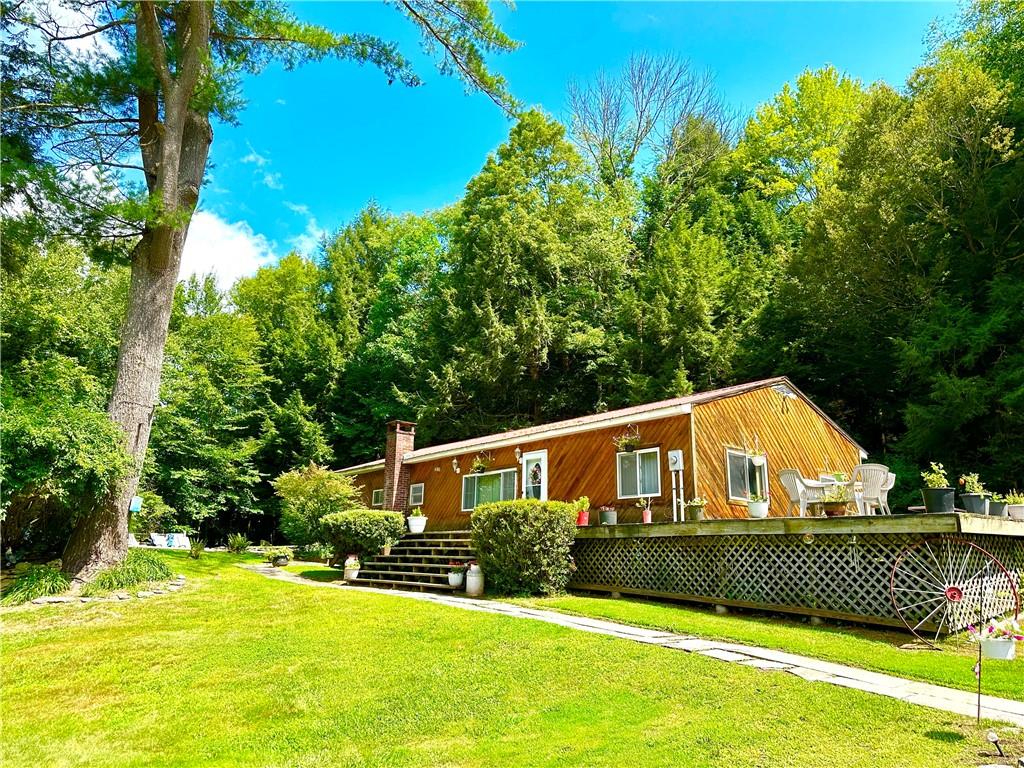 View of front of house featuring a front yard and a wooden deck