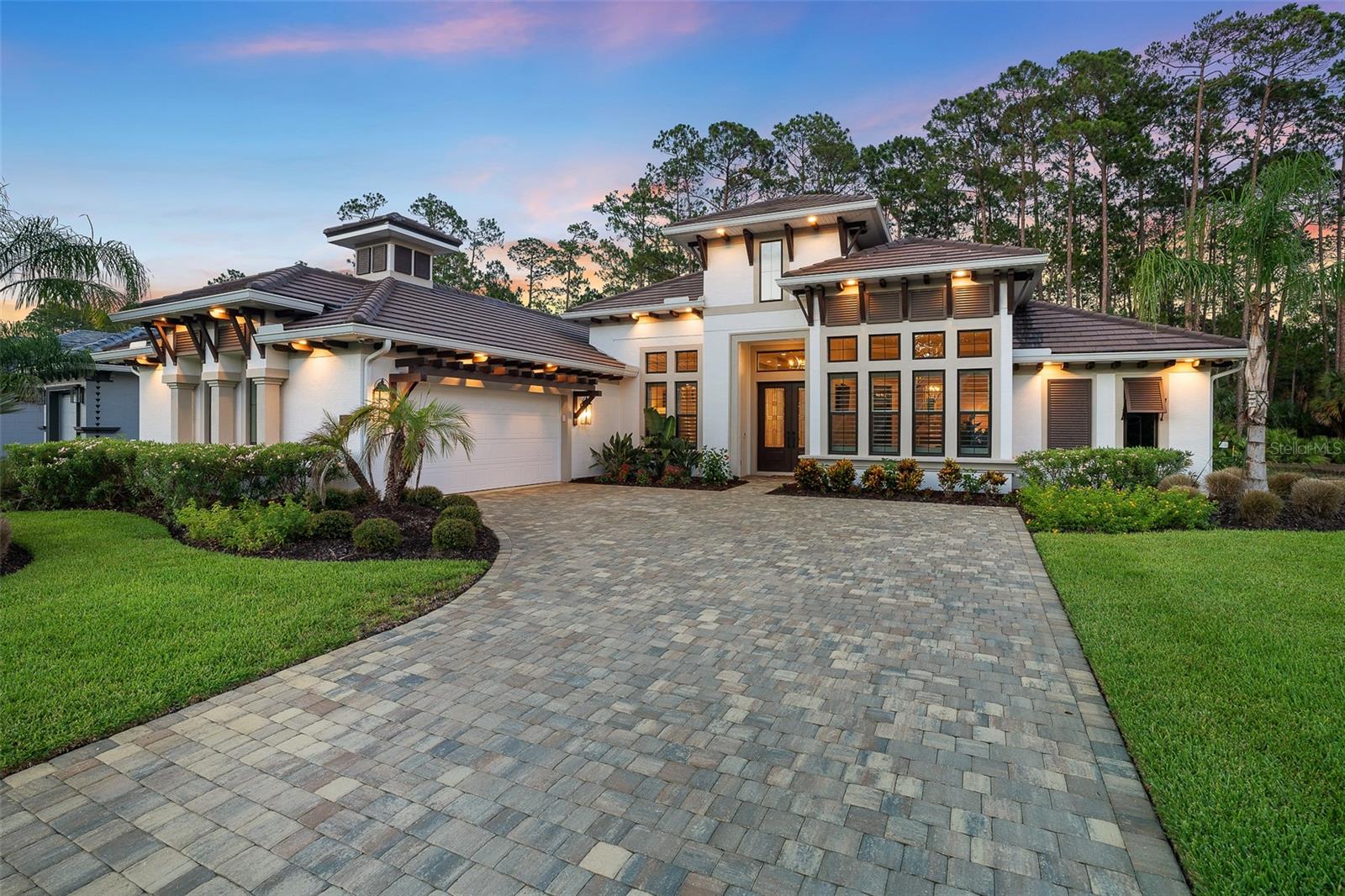 This 2023-built estate home in the gated community of Plantation Bay offers over 3,100 sq ft of refined living with 3 bedrooms, 3.5 baths, and a custom cocktail room on a private preserve lot. Thoughtfully upgraded throughout, the home blends modern craftsmanship with elevated finishes, extensive custom cabinetry, 2025 luxury Monogram appliances, a hidden walk-in pantry with wood built-ins, quartz countertops, oversized island, and a beverage center. The open concept design features soaring ceilings, wide-plank tile flooring, detailed trim work, and a retractable wall of glass that brings natural light and preserve views into the great room, complete with a floor-to-ceiling tiled fireplace and beamed ceiling detail. A breakfast nook overlooks the lanai with a built-in buffet and two beverage drawer fridges, while a formal dining room offers plantation shutters and custom ceiling accents. A transformed flex room serves as a custom cocktail lounge with bespoke cabinetry, quartz counters, and two Sub-Zero wine coolers. The spacious primary suite includes preserve views, lanai access, plantation shutters with blackout shades, dual custom closets, and a spa-like bath with quartz counters, soaking tub, electric toilet, and oversized rain shower. Two guest suites with private baths and walk-in closets provide comfort and privacy, with one offering pool access. The outdoor living area features a 60-ft custom SALT pool with bubblers, elevated tanning ledge, LED lighting, and AquaCal heating and cooling, surrounded by travertine flooring, upgraded screen enclosure, outdoor kitchen with TEC infrared grill, and custom printed side screens for added privacy. Additional upgrades include a whole-house Generac generator with buried propane tank, Culligan whole-house water system with UV purification and reverse osmosis, HVAC air scrubbers, mini-split AC garage, Husky storage cabinetry, upgraded lighting and fans, plantation shutters, blinds, custom barn door, and enhanced cabinetry throughout. Located in Plantation Bay with optional membership offering 45 holes of golf, tennis and pickleball courts, Founders Clubhouse, Prestwick Clubhouse, cabana bar, resort and lap pools, fitness and spa center, bocce ball, and golf-cart-friendly roads. A fully turn-key offering with exceptional detail and quality throughout.
