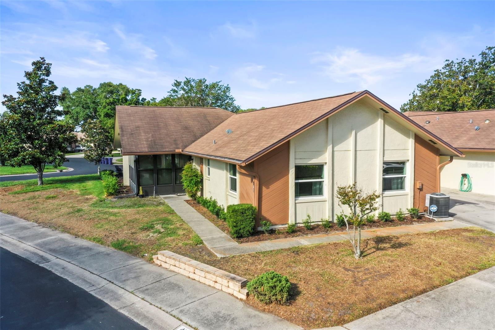 A WONDERFUL GOLF CART FRIENDLY DUNEDIN LOCATION! This beautifully maintained 2 bedroom, 2 bath villa offers the perfect blend of comfort, convenience, and Florida charm. Nestled in a peaceful 55+ community, that is not in a flood zone.  This spacious villa features an open layout, an attached garage with driveway off street parking and located across from the pool. You’ll love the resort style amenities just steps from your door—two sparkling community pools (one heated), tennis courts, shuffleboard, and a fully equipped recreation center that hosts year round activities and social events. Lush landscaping and mature oak trees line the neighborhood, creating a serene, park like setting.One of the community pools sits just across the street, making it easy to enjoy a morning swim or relax with neighbors. Inside, the bright enclosed lanai welcomes the morning sun through its wall of windows, offering a perfect spot for a reading nook, office, or cozy sitting area. This immaculate home was thoughtfully updated in 2016 and has been exceptionally cared for. The bright and sunny enclosed lanai is an ideal spot for an office, sitting room, library or extra space for guests.Just two blocks away, you’ll find a scenic park with a 1 mile paved walking loop, pond views, picnic areas, and a playground. And of course, you’re only minutes from vibrant downtown Dunedin, known for its weekend farmers market, boutique shops, waterfront sunsets, and an incredible selection of restaurants and breweriesThis villa offers the ideal Florida lifestyle—low maintenance living in a friendly, active community close to everything that makes Dunedin so special.