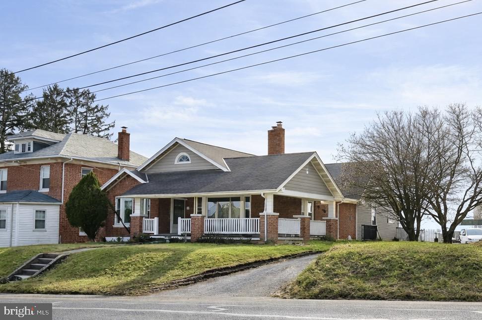 SOLID BRICK HOME WITH HARDWOOD FLOORS THROUGHOUT! Don’t miss this affordable opportunity to own a charming three-bedroom, one-bath home with plenty of yard space, conveniently located close to York but just outside of town, convenient for easy commutes. Built with the quality craftsmanship of the 1930s, this home blends character with modern conveniences. Enjoy original hardwood floors, a beautiful wraparound covered porch, and a finished attic, giving this Cape Cod style home added flexibility and charm. The main level offers two nicely sized bedrooms, a separate dining room, fully equipped kitchen, and a spacious living room. The enclosed porch features upgraded windows and a wood stove, creating a cozy year-round sitting area. The large, sunny yard is perfect for gardening or outdoor entertaining. A two-car garage with an attached workshop provides great space for hobbies or storage. The full basement offers additional storage and a convenient laundry area. Village zoning allows for some business uses as well!  This is a wonderful home with strong bones, great space, and timeless appeal!
