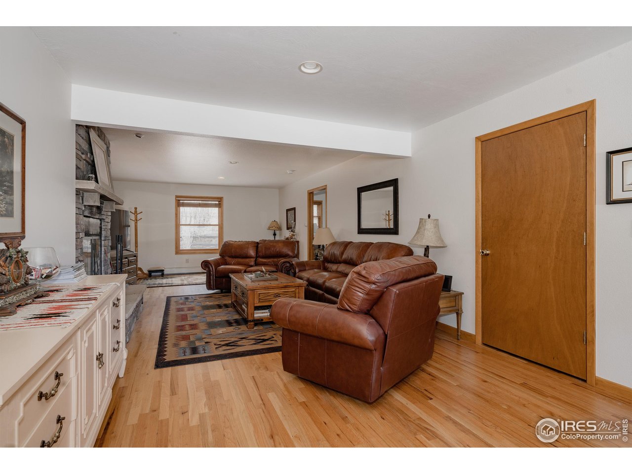 ** Price Improvement ** Tucked among towering pines on a wooded 0.71-acre lot in Village Acres, this thoughtfully updated ranch home offers the kind of mountain living people come to Estes Park for - quiet, comfortable, and surrounded by nature. Elk frequently wander through the neighborhood, and the Rocky Mountains feel like a constant presence just beyond the trees. The main level is warm and inviting, featuring wood floors, radiant heat, and a cozy fireplace, perfect after a day in the mountains. The efficient kitchen blends function and character with a gas range and a striking live-edge island, opening seamlessly to the dining and living spaces. Three bedrooms and two bathrooms on the main floor allow for easy, single-level living. Downstairs, the walkout lower level expands the possibilities with a spacious recreation room, a fourth bedroom, and a 3/4 bath. Step outside to the expansive composite deck, where mature pines, native grasses, and a spring-fed pond create a peaceful, private backdrop for morning coffee or evening gatherings. A detached two-car garage provides plenty of room for vehicles, outdoor gear, and mountain toys, while generous storage throughout keeps everything organized. Quiet, practical, and easy to enjoy, this is a home that fits the Estes Park lifestyle-close to nature, rich in character, and designed for both everyday comfort and weekend escape.