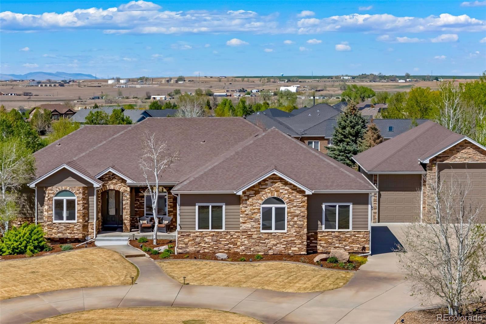 Amazing mountain views with a private, peaceful setting make this exceptional acre property a true stand out. This beautifully designed custom ranch home has 5 beds, 5 baths, and a main floor office with a private entrance. As soon as you enter, you will find spacious, inviting open-concept living with vaulted ceilings, big windows and beautiful hardwood floors. This living area includes a large family room with fireplace, a sitting room, dining space, a spacious kitchen with second dining and a large walk-in pantry. Also, located on the main level is the primary suite with a walk-in shower, jacuzzi tub, walk-in closet, and French doors opening to the deck. There is a second large bedroom on the main level with a private full bath. The private office with warm finishes is ideal for working from home, meeting clients (enter from inside or outside), or just relaxing. The finished walk-out basement expands the living space with a family room/wet bar, 3 large bedrooms, 2 bathrooms, and a spacious flex room or theatre. Outdoor living includes a large covered, main-level deck with incredible mountain views, sunsets, and a built-in gas fireplace. Enjoy a ground-level patio connected to the main level deck and a second patio on the walk-out level. Take in the fully mature, beautiful landscape from all levels. The oversized attached 3 bay garage is 36’ by 36’, fully finished with 10’ overhead doors and built-in cabinets/countertop. The detached RV garage is fully finished, including epoxy floors and an entry door from a private, rear deck. It has expansive space with one bay featuring a 14-ft. door and 45-ft. depth, and the other providing a 12.5-ft. door and 36-ft. depth. Other highlights include dual fuel heating, cooling, and hot water, a whole-house air purification system, backup electric power system. Ideally located with easy access to major highways, airport, shopping, dining, and everyday conveniences, including Costco. Slip over to Todd Creek for a round of golf.