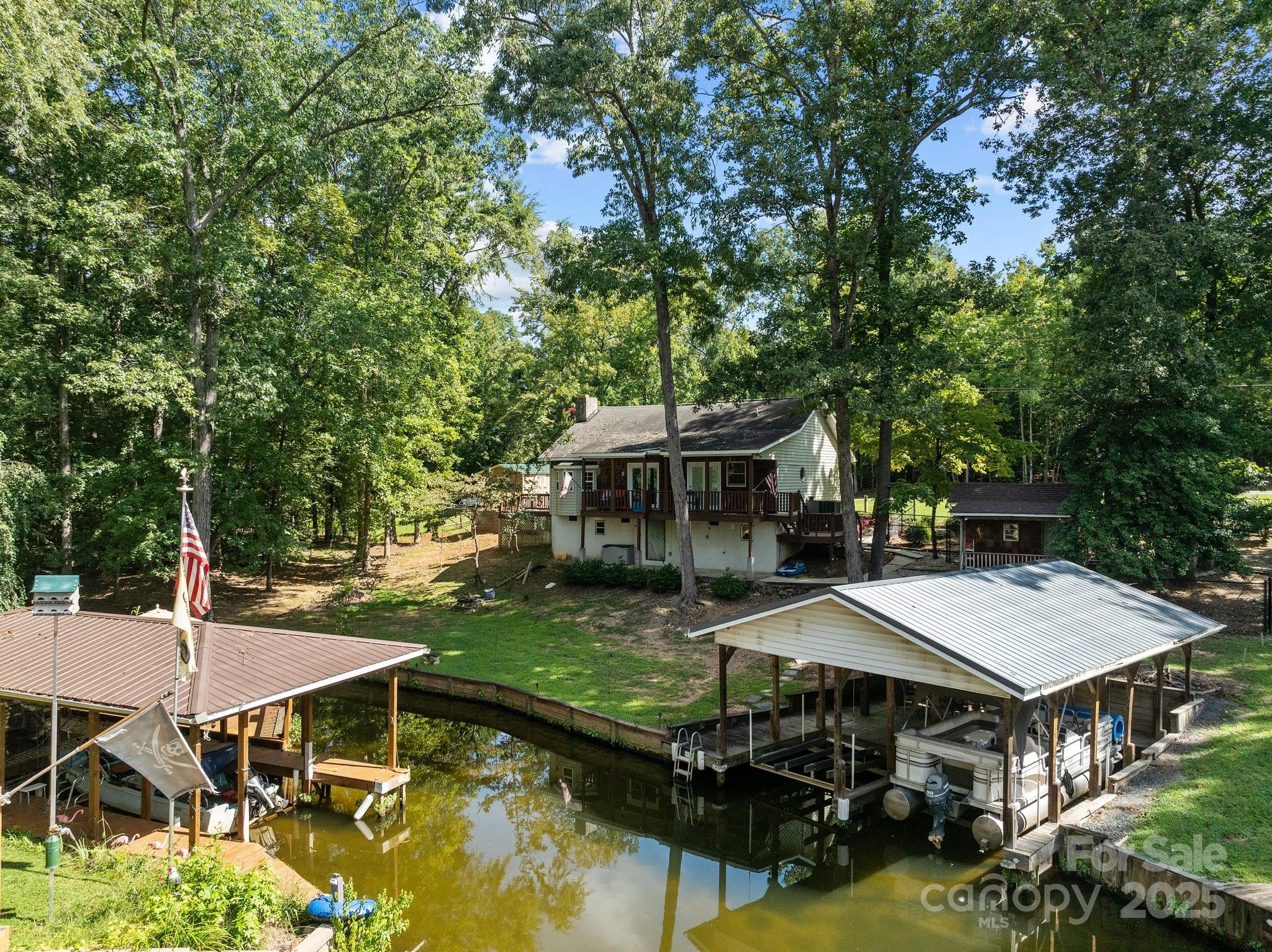 With one downward push of the boat lift switch, 5000 acres of beautiful Lake Tillery are waiting for you to enjoy when you're not relaxing in this charming 2 bedroom 2 bath waterfront home.  A covered lake side porch and open side deck provide lots of space for enjoying the outside.  The vaulted great room helps to make this smaller floor plan feel spacious.  The open living space is convenient for entertaining family and friends.  There is a fenced in area for pets and several outside storage buildings.  The boathouse has 2 slips, 1 that can accomodate a pontoon.  Fairway Shores is a non gated community that has an optional HOA.  Be sure to schedule an appointment to see this home!