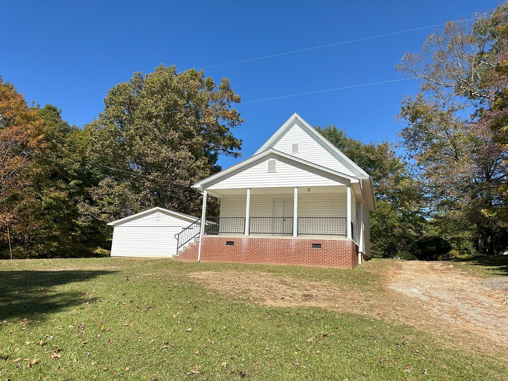 The setting for this historic church is peaceful with gorgeous countryside views, including Buffalo Mountain.  There are may large hardwood trees on the relatively flat lot.  This is a unique opportunity to purchase a 1910 church and either use it as a church or renovate it into a residence.  The church has 1,180 sq feet, mostly in the sanctuary but there are 2 large bathrooms with toilets and sinks, but no shower or tub.  The sanctuary features a large open space (26x80) which is heated by baseboard electric.  There is no air conditioning.  The pews are available to convey with the property or if you don't want them, the church will remove them.  The Fellowship hall beside the church has 768 square ft. and has heat and electricity but no running water.  It has vinyl siding and a shingle roof.  The church has vinyl siding and a metal roof.  There is also a storage building and a covered building/pulpit for outside services.