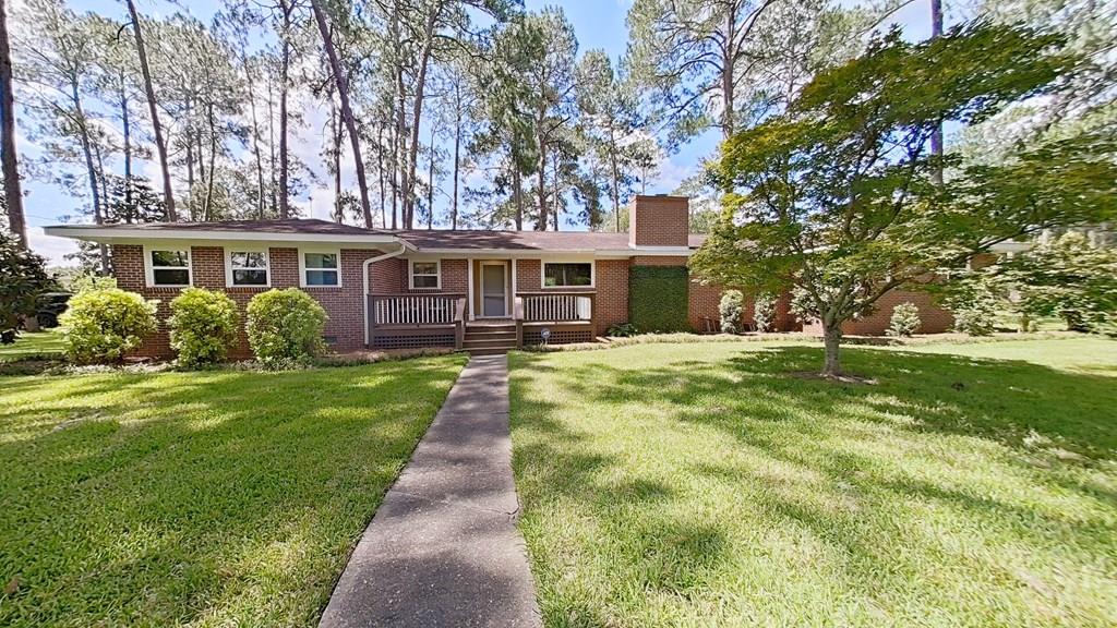 Welcome home to this beautifully remodeled, move-in-ready traditional brick home with modern contemporary touches. Immaculately maintained and pre-inspected, this rare find is situated on a beautifully landscaped corner lot of nearly an acre in town, offering privacy while being conveniently close to shopping, dining, schools, and everyday amenities.  Step inside to a stunning foyer featuring a cozy reading nook filled with natural light and a spacious walk-in laundry room. Just off the foyer is a versatile bonus room with double doors and a second wood-burning fireplace, making it ideal as a second living area, home office, or potential in-law suite. The inviting living room showcases a wood-burning fireplace, built-in bookshelves, rich wood paneling, and sliding glass doors that lead to a large, private patio—perfect for relaxing or entertaining. The spacious dining room is filled with natural light from a beautiful picture window and features gorgeous hardwood floors. Hardwood flooring extends throughout much of the home and appears to be in excellent condition. Two bedrooms are currently carpeted, with hardwood flooring underneath. The updated kitchen opens to the dining area and features tile countertops, stainless steel appliances, and a large bay window overlooking the beautifully landscaped front yard. The spacious primary suite offers custom built-in cabinetry, a beautifully tiled shower, new vanity, and built in cabinets. The second bathroom has also been updated with new tile flooring, built-in medicine cabinets, and a tub/shower combination. Additional features include all newer vinyl windows and exterior doors throughout, a circular concrete driveway, a private backyard, and exceptional curb appeal. Homes with this much character, space, and an acre in town are a rare find. Schedule your private showing today!