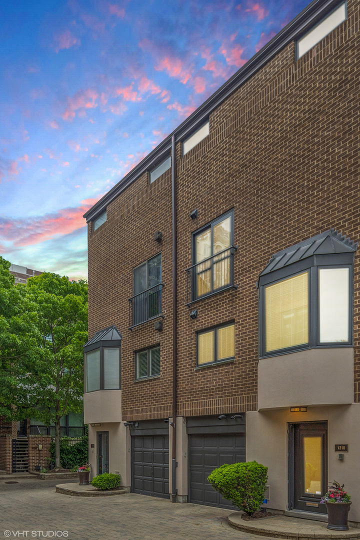 3 bed + den/2.5 bath townhome with 2 private outdoor spaces and attached heated 1-car garage in the heart of Gold Coast's highly desirable Sutton Place community! Onyx tile entryway foyer leads into this spacious 4-story townhome with hardwood flooring and tons of closet space throughout. Newer kitchen and appliances with stone countertops opens into the main floor dining and family room complete with gas fireplace and south facing Juliet balcony. Wall of south facing windows spanning all 4 stories allows for natural light throughout the day! Entire top-floor primary suite includes a full-width private roofdeck terrace with Trex decking, cathedral ceilings, a second wood burning fireplace, and a huge walk-in closet and updated en-suite bathroom. Custom built-ins, open shelving and millwork throughout. First floor family room leads out to private enclosed courtyard! Full sized side-by-side washer/dryer. Professionally managed 50-unit pet-friendly HOA with private gated drive includes 24/7 on-site security, professional landscaping and snow removal. Complex is fully owner occupied in a truly unbeatable location. Building is all brick/ masonry construction. Steps to Michigan Ave, Old Town, lake path, North Avenue and Oak Street Beaches, Red Line, Equinox, everything Gold Coast has to offer!
