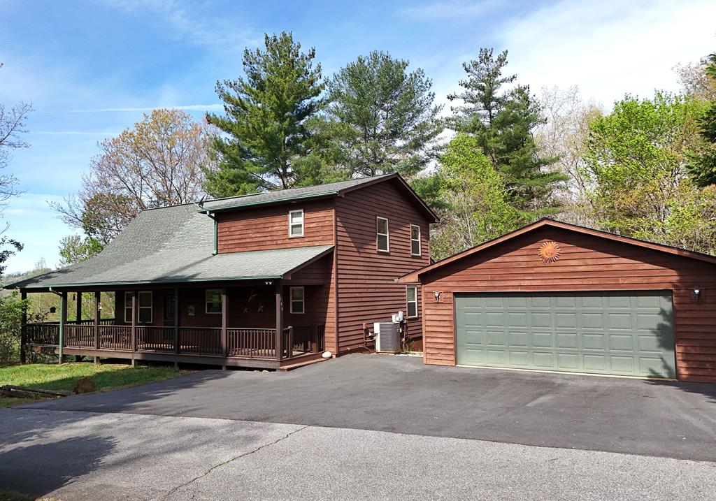 Escape to this beautiful chalet-style cabin in a fantastic location, offering mountain views and two inviting porches, including a spacious wraparound deck perfect for relaxing or entertaining. Inside, you'll find a large open-concept living, dining, and kitchen area, highlighted by a stunning stone gas log fireplace in the living room. The thoughtfully designed layout features a bedroom and full bath on the main level, with an additional private bedroom and bath upstairs. Enjoy the convenience of main-level laundry and the added bonus of a two-car detached garage. The full unfinished basement provides endless potential, and with a three-bedroom septic already in place, there's plenty of room to expand and create additional living space. Select furnishings are negotiable and may be available on a separate bill of sale.