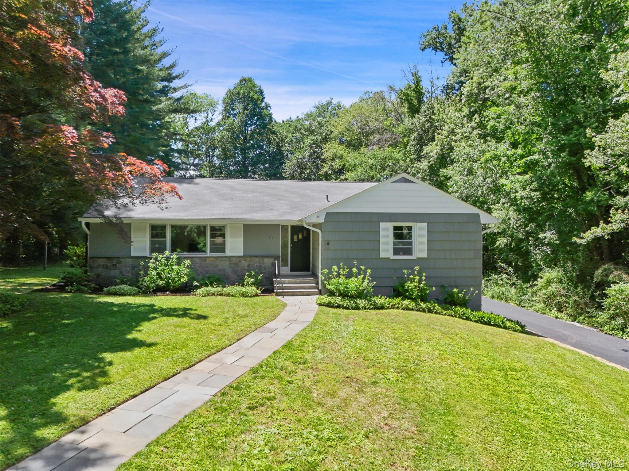 KATONAH VILLAGE!  Nestled on a private road in charming Katonah sits this lovely 2BR ranch home.   Front walkway is framed by a large Red maple, mature hydrangeas, and features a spacious flat front yard.  To the left of the front entry is a large, light-filled Living Room featuring a wood-burning fireplace. The Living Room flows directly into the Dining Room, with pocket doors connecting to the adjoining Kitchen.   The spacious eat-in Kitchen blends vintage charm with thoughtful updates, showcasing restored and painted original cabinetry, a Frigidaire oven, Bosch stainless steel dishwasher, fun pink SMEG refrigerator, vintage wallpaper, and classic checkerboard floors.   To the right of the front Foyer, a hallway leads to an updated Powder Room a spacious Primary Suite with three large closets  and an Ensuite Bath complete with a large cast iron tub and charming white penny tile flooring.   A generously sized Second Bedroom with double closets and an additional hallway closet complete the main level.  Just off the Kitchen, a door leads to a beautiful private bluestone Terrace, offering an ideal setting for morning coffee while enjoying views of the expansive, private yard and garden area,   The yard is fully fenced, making it ideal for pets.   A separate covered Terrace/Breezeway enhances the home's outdoor living space - perfect for relaxing, entertaining and year-round outdoor enjoyment.  Spacious garage with an upper loft area.  Hardwood flooring runs throughout the home.  Basement is partially finished.  New asphalt Driveway, Entirely New Septic System with a 1250 tank and new fields.  This sweet Katonah Village gem is just moments from shops, restaurants, parks, and the train.  Not to be missed!