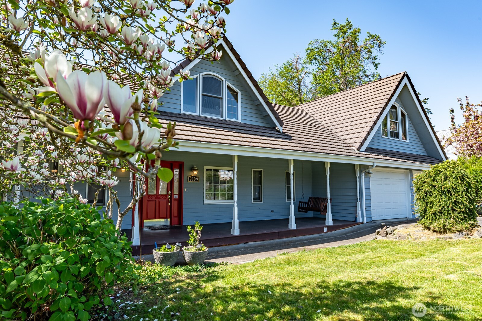This home blends charm and functionality with great curb appeal, a covered porch, and lush landscaping, including a magnolia tree, hydrangeas, and rhododendrons. The backyard oasis features a creek, bridge, and space for a greenhouse or garden, ideal for relaxing or enjoying s'mores by the firepit. Inside, vaulted ceilings, hardwood floors, and a river rock fireplace add warmth, while the kitchen offers double ovens, a gas stove, and granite countertops. Additional perks include a fire-resistant tile roof, 2-car garage, bonus 770 SF shop/garage, and ample storage. Conveniently located near the hospital, schools, and shopping, yet feels like a private retreat.