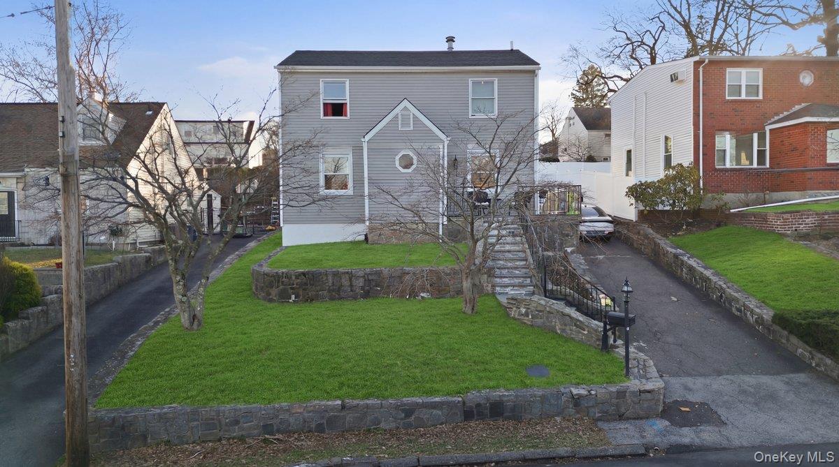 Nestled in the highly desirable Westchester Hills neighborhood of Yonkers, this beautiful Colonial-style home perfectly blends classic charm with modern updates. Featuring 4 spacious bedrooms and 2 full bathrooms, this sun-drenched residence offers comfortable family living with style and functionality. The updated kitchen boasts custom cabinetry and granite countertops, flowing seamlessly into the dinette area and an inviting living room—ideal for gatherings and everyday life. The first floor also includes a versatile den or home office and a convenient hall bathroom. Upstairs, the primary bedroom features ample closet space, complemented by three generously sized bedrooms and a full hall bathroom. The lower level offers additional living space, perfect for a family room, play area, or hobby space, along with plenty of storage, a utility room, and laundry area. Recent upgrades include a new roof, siding, and windows, ensuring peace of mind for years to come. The home sits on an expansive, fully fenced lot with a detached garage and a large driveway, offering both privacy and plenty of outdoor space. Enjoy warm summer evenings on the patio, perfect for entertaining. Ideally located for commuters, this home is just minutes from buses, trains, major parkways, shopping centers, and a short drive into NYC. Functionality meets contemporary living in this picture-perfect Home—where comfort, convenience, and style converge.