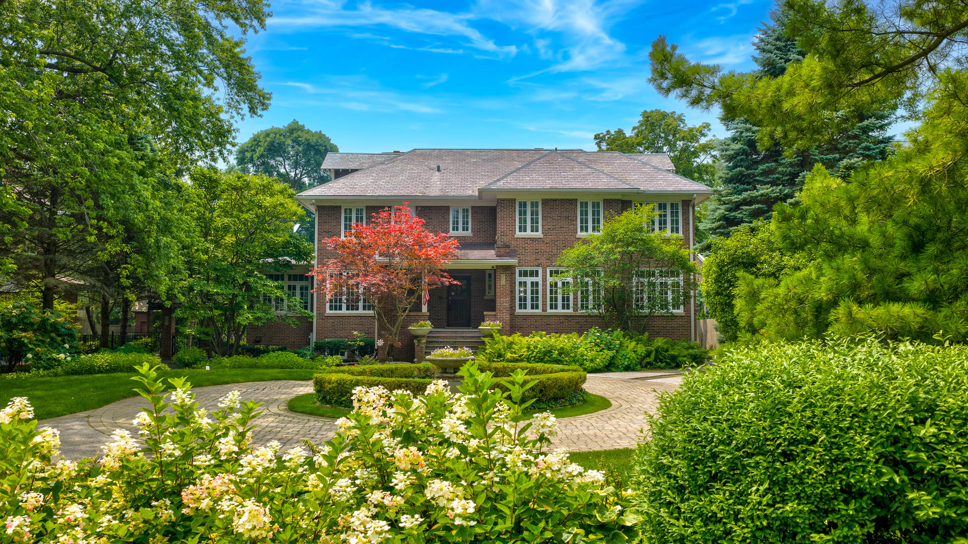 Perfectly located on soughtafter Sheridan Road in the heart of Kenilworth, this stately redbrick colonial sits quietly behind a circular drive and landscaped gardens, offering wonderful privacy on nearly a halfacre. Originally built in 1918, the home has been extensively renovated to blend timeless character with the comfort and functionality of modern living. Large windows throughout capture morning sunrises over the lake and afternoon light reflecting off the backyard pool. A gracious foyer anchors the original entry and opens to an elegant dining room and a beautiful living room with a focal fireplace. Just beyond is a sunfilled sitting room or office wrapped in windows-an inviting place to work or unwind. The main living area centers around an oversized kitchen with custom cabinetry, highend appliances, a spacious island, and a bright breakfast room. The adjacent 650 sq. ft. family room features a 10foot ceiling and offers an easy, comfortable space for everyday living. A second powder room and a welldesigned mudroom help keep everything organized. As you move upstairs, the primary suite feels like a true retreat with fireplace, spainspired bath, and a skylit walkin closet. All family bedrooms are generous in size: one enjoys its own timeless ensuite bath, while the other two share a large common room-ideal as a hangout or homework space-and a beautifully updated bathroom with a double vanity. The third floor includes a bedroom, office, and full bath, creating the perfect setup for a teenager, guests, or anyone wanting extra privacy. The basement offers a great recreation room with multiple seating areas, a handsome wine room, and exceptional storage, along with space for an additional laundry area. Outdoors, the home is designed for easy entertainment with manicured grounds, multiple patios, and a beautiful pool. One bay of the threecar garage could even be transformed into a fantastic pool house. All of this is just a short walk to the beach, parks, the revitalized Plaza Del Lago with Starbucks, shops, and restaurants, as well as the awardwinning school - Joseph Sears (JK-8) and New Trier.