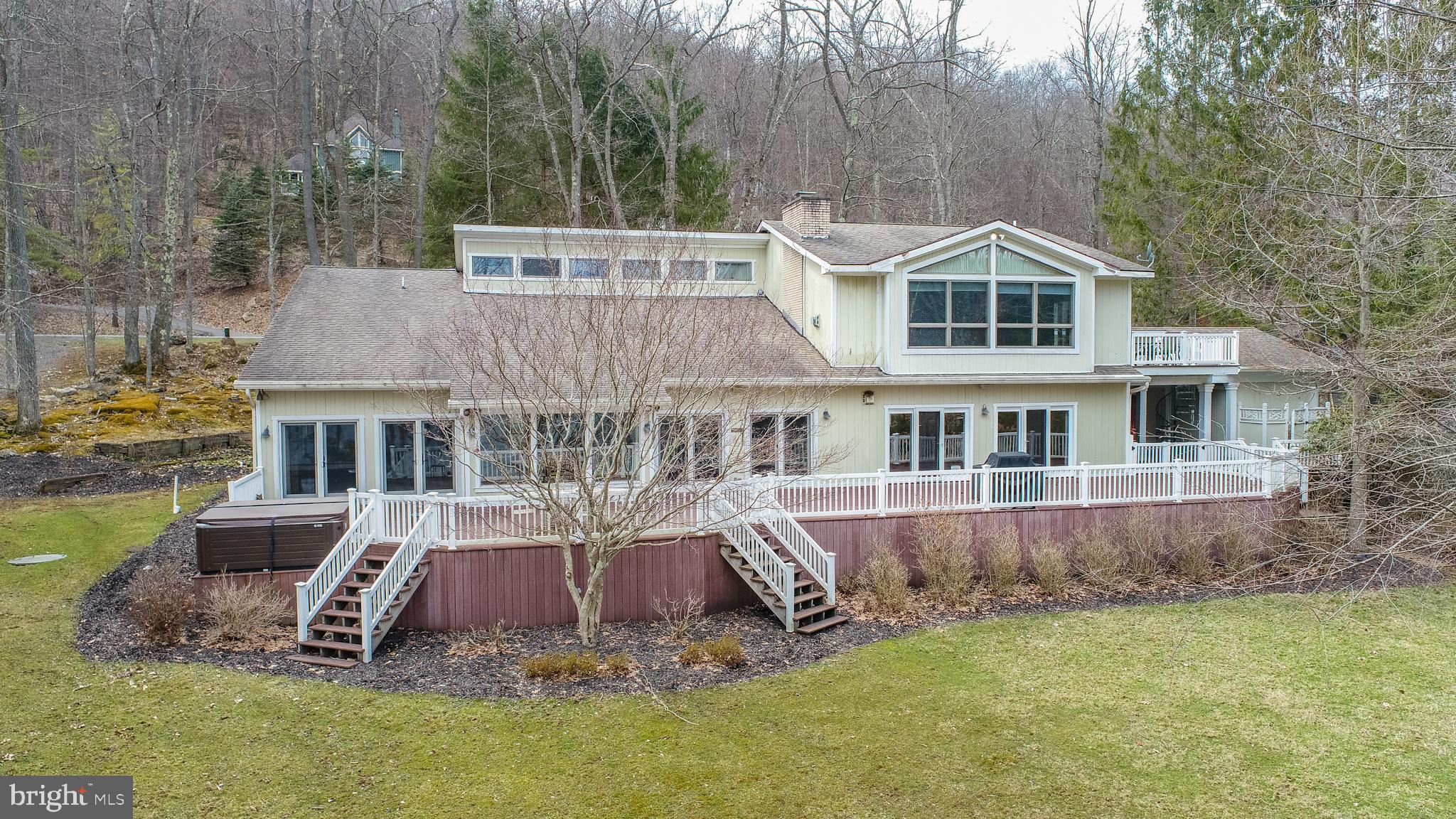 This stunning Deep Creek Lake waterfront home offers an unparalleled lakeside living experience with 200 feet of prime lakefront and a private Type A dock. Located just down the street from the base of Wisp Resort, this property is ideally positioned for those seeking both a tranquil retreat and easy access to year-round outdoor activities. Boasting over 5,000 square feet of living space, this home offers generous room for both family and friends to enjoy.Upon entering, you are greeted by two grand family rooms, each designed to take full advantage of the breathtaking natural light and sweeping lake views. These spacious areas provide a perfect setting for relaxation, entertaining, or cozying up by the fire. The large kitchen is a true centerpiece of the home, with ample counter space, high-end appliances, and plenty of room for preparing meals while enjoying the company of loved ones. Adjoining dining areas offer perfect spots for both casual meals and more formal gatherings.For outdoor enthusiasts, the full-length lakefront decking provides an exceptional space for entertaining or simply enjoying the beauty of Deep Creek Lake. Whether you're hosting a summer barbecue or taking in a peaceful afternoon, the views from this expansive deck are nothing short of spectacular. The private Type A dock allows for direct access to the lake and is permitted for 2 powered boats and 1 non-powered boat, making it easy to enjoy water sports, fishing, or just relaxing and swimming off of the dock.The home’s bedroom configuration is as impressive as its living spaces. The master suite offers a serene retreat with stunning lake views and a spa-like en suite bathroom. Additionally, there is a smaller master suite on the main floor, perfect for guests or multi-generational living. Upstairs, you'll find a set of Jack and Jill bedrooms as well as a 5th bedroom on the top floor, offering privacy and a quiet escape.Situated on Marsh Hill Road, this home offers the perfect balance of privacy and convenience. With Wisp Resort just moments away, you have access to skiing, snowboarding, hiking, boating, and golf, making this a prime location for outdoor enthusiasts. Whether you're seeking a permanent residence, a vacation getaway, or an investment property, this waterfront gem provides everything you could want in a Deep Creek Lake home.