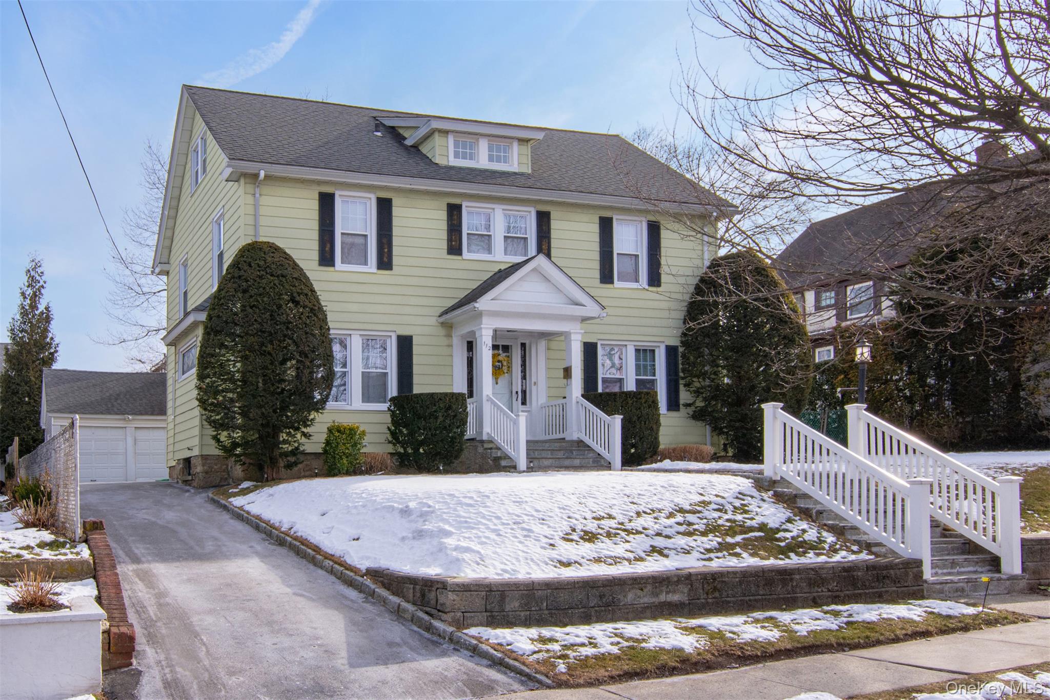 Gracefully set on a coveted tree-lined street, 112 Buckingham Road is a stately five-bedroom Dutch Colonial, offering timeless architectural elegance and refined modern comfort. The main level is thoughtfully designed for both gracious entertaining and everyday living. A welcoming entry foyer opens to an elegant formal dining room highlighted by a striking stained-glass window and refined moldings, as well as an expansive living room anchored by a wood-burning fireplace. The dining room flows seamlessly into a beautifully renovated, inviting eat-in kitchen with direct access to the private, nicely landscaped backyard. Adjacent to the living room, a light and bright sunroom with three exposures provides a warm and cozy retreat, ideal for relaxing or entertaining. The second level offers four well-appointed bedrooms, each enhanced by original hardwood floors, classic moldings, and abundant natural light. The spacious primary bedroom includes an ensuite bath, while the three additional bedrooms are well-proportioned and share a tastefully updated hall bathroom. The third floor reveals a charming fifth bedroom rich in character, a full hall bathroom, additional storage and a delightful landing with original hardwood flooring, making it ideal for guests, a private office, or a quiet sanctuary. The lower level provides approximately 970 square feet of flexible finished space not included in the total square footage, well suited for recreation, fitness, laundry, and storage. Beautifully preserved period details, refined moldings, and original hardwood floors convey timeless elegance throughout the home. Western exposures bathe the residence in natural light, accentuating its gracious proportions, while the level, landscaped backyard offers a serene setting for outdoor enjoyment, completing this exceptional offering in one of Bryn Mawr’s most desirable locations.