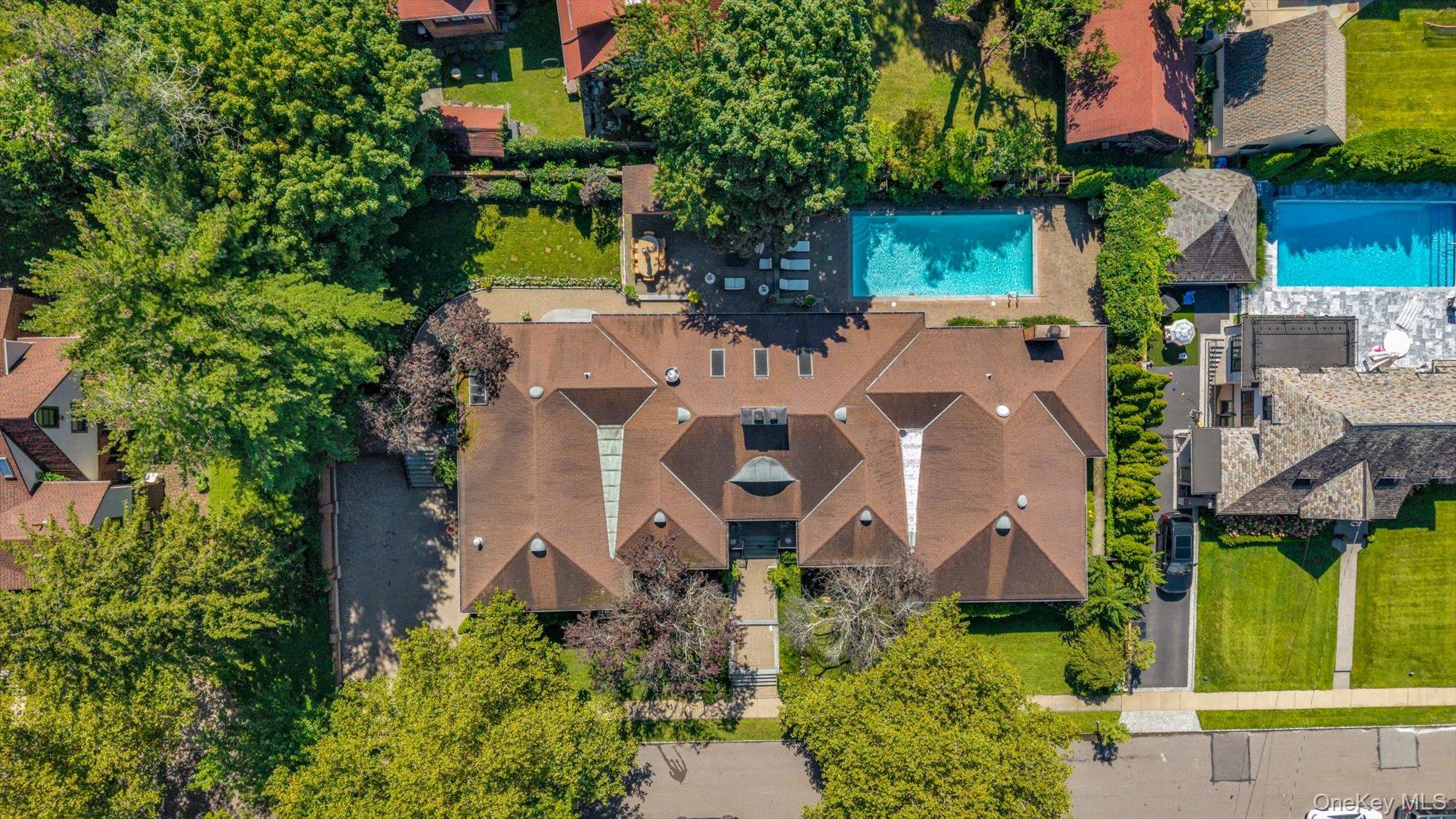 This SPRAWLING Ranch in the heart of the waterfront community of Douglas Manor sits on an impressive 16,000 sq. ft. lot. With over 9,800 sq. ft. of living space, this home is elegant yet inviting and thoughtfully designed with generously sized rooms and exceptional amenities. From the moment you enter the grand foyer with its dramatic 20-foot domed ceiling, you’ll notice the beautiful custom millwork, elegant archways, architectural ceilings, and carefully placed skylights that bring an abundance of natural light into the home. An impressive gallery-style corridor, framed by graceful archways, runs through the heart of the home, creating a seamless flow from room to room. Radiant heat beneath all tile and stone floors, along with multiple heating and cooling zones throughout the home, provide exceptional year-round comfort.Over 4,800 sq. ft. of living space on the main floor features four spacious bedrooms, including an impressive primary suite with a spectacular two-level custom walk-in closet. A large home office offers the flexibility to serve as an additional bedroom. The sunken formal LR, formal DR, and den provide large spaces for both everyday living and entertaining. The gourmet kitchen and breakfast area feature a large center island with an additional sink and top-of-the-line appliances, including a Sub-Zero refrigerator, Viking stove and warming drawer, wine refrigerator, dishwasher, and microwave. Gas fireplaces add warmth and ambiance throughout the home, while radiant heating, central vacuum, and a whole-house generator capable of powering the entire home add another level of comfort, convenience, and peace of mind. French doors from the kitchen open to the patio and backyard. Enjoy the in-ground pool, outdoor kitchen, and generous space for dining, lounging, and gathering with family and friends.And then there’s the lower level - another 4,800 sq. ft. and an entertainer’s dream! This expansive space features an in-law suite, large entertainment room, wine room, wet bar, gym, and your own private spa retreat complete with a steam room and sauna.An attached two-car garage and wide driveway with parking for four additional cars provide plenty of off-street parking.The Douglas Manor Association maintains the shared waterfront and provides private security. Residents also have the opportunity to join the Douglaston Club, which offers a pool, tennis courts, dining, and year-round social events.