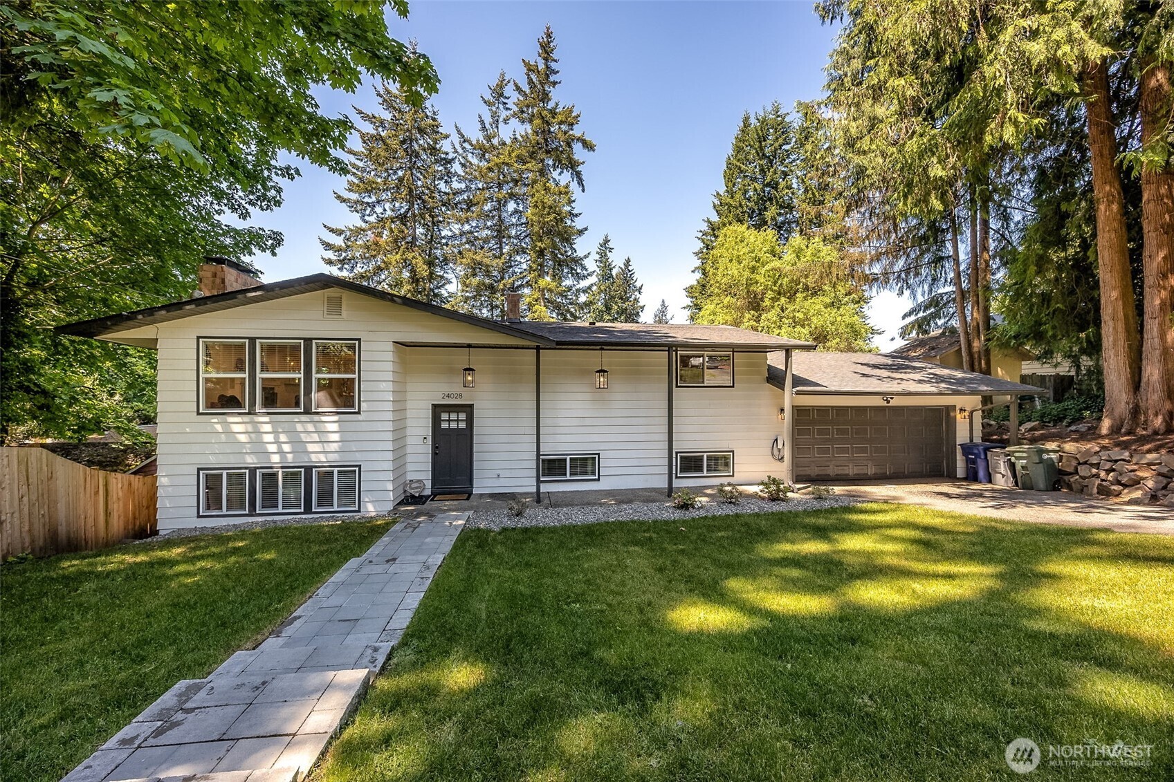 Rare Bothell gem just minutes from Saint Edward State Park offers privacy and luxury on a secluded 0.3-acre lot with dual street access. This 2,512 sq ft home features high-end renovations, an open floor plan, quartz countertops, and stainless steel appliances. The upstairs primary suite includes an ensuite bath and walk-in closet, while a spacious downstairs bedroom with dual closets offers flexible space for guests or a home office. Two additional oversized bedrooms add versatility. Enjoy a pro-installed pickleball court, sport hoop, new furnace and A/C. Recent updates include a new roof, windows, and more. Pro-installed Tesla charger & 2 car garage. Steps from Shelton View Forest and close to Northshore schools, Microsoft, and AWS.