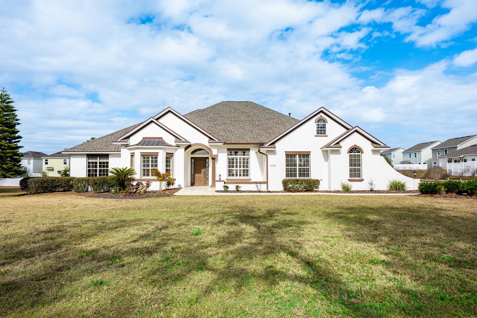 Virtually Staged. Ask about a lender provided RATE BUY-DOWN CREDIT on this home! ***RARE OPPORTUNITY FOR 2+ ACRES ADJACENT TO THE VILLAGES!*** Private Estate Minutes From The Villages ***** Set on two spacious lots totaling 2.28 ACRES, this one-of-a-kind ESTATE HOME in Wildwood delivers the rare combination of luxury, land, and freedom – NO HOA, golf-cart friendly, and just 2.2 miles from Brownwood Paddock Square in The Villages! Formerly an executive model home, the property has been fully REMODELED and thoughtfully UPGRADED, offering a MOVE-IN READY lifestyle with room to EXPAND, build, or relax, unwind and enjoy the space around you. ***MAJOR UPDATES INCLUDE: a BRAND NEW ROOF (2025), 2 NEW TRANE A/C SYSTEMS (2025), a NEW WATER HEATER (2025), FRESH INTERIOR & EXTERIOR PAINT, UPDATED LANDSCAPING, and NEW FENCING on the back and sides for added privacy. Every big-ticket item has already been handled – so you can focus on living! Curb appeal is immediate, with a side-facing OVERSIZED 2-CAR + GOLF CART garage, manicured landscaping, and the presence that only a former model home can offer. Inside, over 3,400 square feet of curated living space unfolds with high-end finishes, CERAMIC TILE and LUXURY VINYL PLANK FLOORING throughout, flexible formal areas, and an open, inviting family room that flows seamlessly into a light-filled breakfast nook and a timeless kitchen with a modern edge – perfect for any style! The home chef’s dream kitchen features sleek CULTURED GRANITE COUNTERTOPS, an ISLAND with prep sink, and NEW GE CAFE APPLIANCES, ideally suited for both everyday living and entertaining with ease. The sprawling OWNER’ SUITE is a true retreat, privately tucked into its own wing of the home. French doors open directly to the lanai – sip your morning coffee – while the suite itself boasts a massive CUSTOM CLOSET with built-in desk and a spa-inspired en-suite bath with dual sinks, lighted mirrors, soaking tub, and an oversized walk-in shower. Guest bedrooms are located on the opposite side of the home with a beautifully updated full bath between them, delivering privacy and comfort for everyone. Outdoor living truly shines here - an expansive COVERED LANAI with a BRAND NEW OUTDOOR KITCHEN  – complete with stone finishes, stainless hood, gas range, sink, and built-in beverage refrigerator – overlooks the HEATED POOL and seemingly endless backyard. A convenient FULL POOL BATH opens directly to the lanai, making entertaining effortless with the opportunity to add a door and create an en-suite to the neighboring bedroom. Mature trees create a tranquil, private setting that feels worlds away, yet keeps you minutes from a variety of shopping, dining, and entertainment. The second attached lot is fully buildable, offering endless possibilities – add a detached garage, workshop, guest home, or create a multi-generational setup. To further enhance privacy and long-term landscaping value, the sellers have recently planted a combination of fast-growing privacy trees along the property borders, including Leyland Cypress and Southern Red Cedar. These trees are widely known for their rapid growth rate and dense evergreen foliage . With no HOA restrictions, space for toys, hobbies, or future expansion, and proximity to The Villages, this property stands in a category all its own. This is not just a home, it’s a lifestyle upgrade! Call today to schedule your tour and let us say WELCOME HOME! ***Seller may consider buyer concessions if made in an offer***