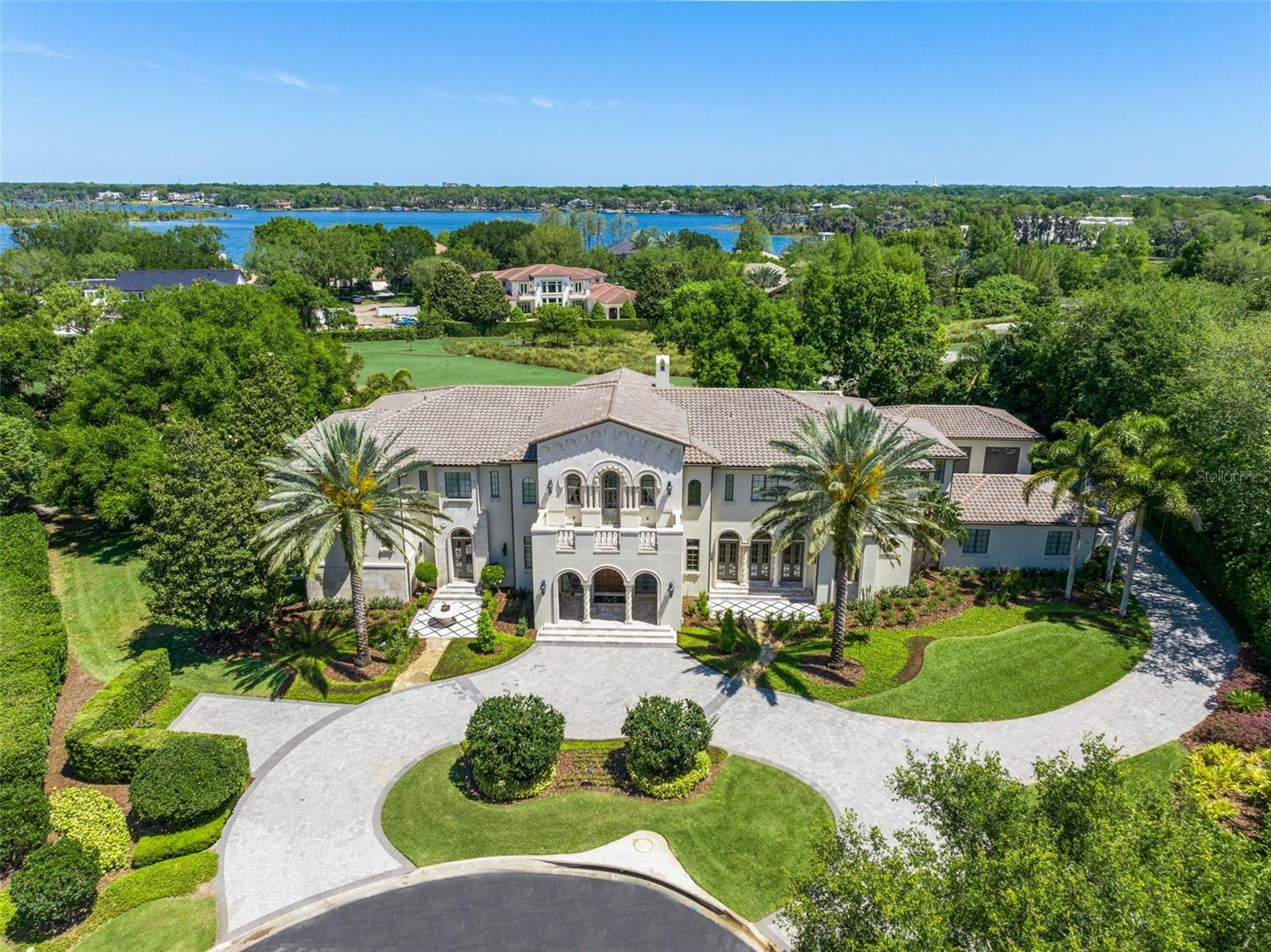 Under contract-accepting backup offers. Presenting one of Isleworth’s most iconic mansions: magnificent and grand, impressively positioned along the 14th fairway of the Isleworth golf course, behind the secured and guarded gates of one of the world’s most prestigious private golf club communities.  This palatial estate offers a stunning mix of stately elegance and classic grandeur - and has been just reimagined with new custom touches throughout and topped with a brand-new roof.  Enter the stylish foyer and be greeted with marble flooring, graceful millwork, a grand staircase, and an upstairs landing with beautiful iron railings to accentuate a majestic showplace beyond. Impressive floor-to-ceiling windows in the two-story living room, a thick and detail-crafted marble mantel fireplace, and rich wood flooring highlight the distinctive custom features found throughout. The sumptuous master retreat offers a luxurious haven, adorned with ornate refinement and French doors and shutters that reveal a private terrace. The master bath features an expansive closet, new and refreshed vanities, a new separate steam shower with scents, and a beautifully crafted giant roman spa-inspired shower room with jetted tub as a centerpiece. A colonnade hall spans the first floor of the estate, spanning from the primary retreat to the expansive dining room. A central family activity space is a favorite spot for homework, crafts, and activities. The well-appointed chef’s kitchen with large island, double sinks, gas cooktop with hood and pot filler, built-in refrigerator, and premium appliances are ready to satisfy every culinary desire.  An espresso bar with beverage station and separate butler’s pantry are perfectly suited for entertaining or everyday use. The casual family dining room and family room are both generous in size and are bathed in natural sunlight. Glass sliders reveal a sizable, covered patio with stone flooring and summer kitchen with grill and hood, offering direct access to the massive resort-style pool, half-basketball court, and the manicured grounds. Upstairs are four ensuite bedrooms including a junior master, Hollywood-style home theater with bar, balcony access, second laundry room, and second staircase. Home also features an elevator for effortless second-floor access, child’s playroom and gym. Other recent upgrades include many technological updates. Furniture is negotiable. Located in the ultra-secure “Butler Side” of Isleworth featuring private gates and very limited access. The 600-acre Isleworth community, surrounding the Butler Chain of Lakes, is a residential enclave that sets the standard of excellence for Central Florida living. On-site home services are available for a carefree lifestyle. Isleworth Golf and Country Club, which is located within the community, offers various membership opportunities and is recognized as one of the Top 100 Platinum Clubs of the World.