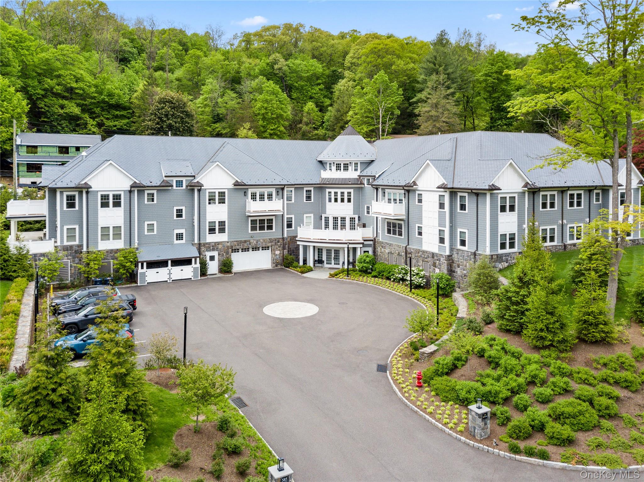 Single-floor living at The Byram, a boutique condo set just off Main Street in the heart of Armonk village. Inside, the kitchen, dining, and living areas share one continuous great room under tray ceilings and abundant natural light. The chef's kitchen anchors the space: Viking range, stainless built-in refrigerator, white shaker cabinetry, and a waterfall-edge quartz island. The primary suite occupies its own wing — marble en-suite with glass-enclosed shower, freestanding soaking tub, and double vanity, plus two walk-in closets. A second bedroom with private en-suite and walk-in closet sits on the opposite side of the home. Off the great room, a separate room serves as a home office, library, or guest study. A guest powder room, in-unit laundry, and a private terrace framed by mature trees complete the residence. Building amenities include a fitness center, residents' lounge with grand piano, one assigned garage parking space, and a dedicated storage unit. Pet-friendly. Minutes from Armonk's restaurants and shops, with Westchester Airport, the Hutch, and the Metro-North express to Grand Central all a short drive away.