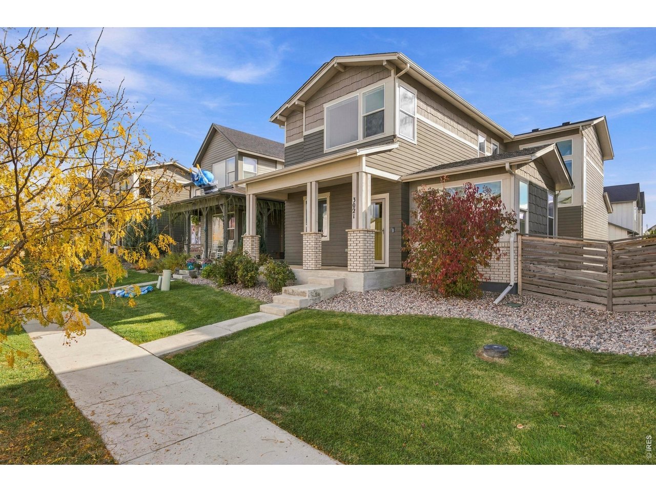 Welcome to 3021 Conquest Street, a 2019 Hartford Homes Galileo plan in north Fort Collins' Mosaic neighborhood, with a covered front porch facing an association-maintained green and a rear-load garage off the alley. The two-story craftsman offers 4 beds, 3.5 baths, 2,944 finished sq ft and 3,050 total sq ft, with a basement finished under permit in 2021 and a new furnace and AC in 2025. The open main level has wood-look vinyl plank flooring throughout. The kitchen pairs white shaker cabinets with white quartz counters, a gray subway tile backsplash, a large island with seating for four, a gas range, stainless appliances and a window over the sink. The dining area sits in a vaulted bump-out with windows on three sides. The living room centers on a floor-to-ceiling tiled gas fireplace flanked by open shelving, with a wide sliding door to the back patio. A built-in bench and cubbies at the drop zone and a powder room complete the main floor. Upstairs, the vaulted primary suite has a ceiling fan, a dual-sink bath with a glass-enclosed tile shower and a walk-in closet with a custom closet system and lighting. Two more bedrooms with ceiling fans share a full bath with a tub, and a bright loft works as an office or play space. The laundry room is on the bedroom level. The finished lower level adds a large rec room with recessed lighting that is plumbed and ready for a wet bar, a fourth bedroom and a bath with a tiled walk-in shower. Outside are a concrete patio, a side courtyard, a lawn and cedar privacy fencing. The HOA covers front yard maintenance, front snow removal and access to Mosaic's two pools and community park, with a new city park planned in the neighborhood. Close to Old Town, CSU and I-25. Vacant, staged and easy to show, welcome home!