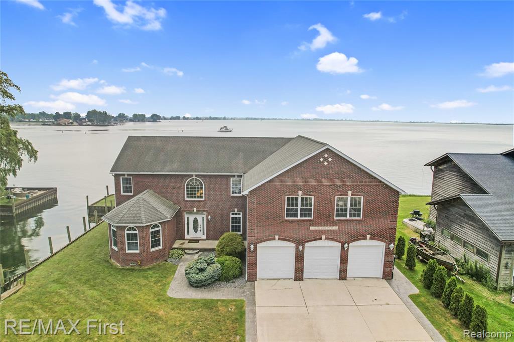 Location, location, location! This rare waterfront gem combines direct frontage on Anchor Bay/Lake Saint Clair with a private canal inlet for your boats and water toys - offering an impressive 229 feet of total waterfront to enjoy. A stamped concrete patio runs the full length of the home, perfect for lakeside entertaining. The new seawall (installed in 2021) offers peace of mind for years to come, while the expansive three car garage adds convenience and storage. A spacious, airy foyer welcomes you the moment you step inside, offering immediate views of the sparkling water beyond. Wake up to picturesque lakefront scenery in the first floor primary suite, complete with direct patio access, a generous walk-in closet, and a spa-like bath featuring both a walk-in shower and soaking tub.  Two additional bedrooms on the main level provide versatile options - ideal for an office, flex space, or guest rooms - while three more bedrooms upstairs complete the home with ample accommodations. The enormous game room is a highlight of the home, offering endless space for entertaining, holiday gatherings, and events - a half bath adds extra convenience for guests. Dual HVAC units produce ultimate efficiency, with one being replaced in 2024. New tankless hot water in 2024. Luxury Vinyl flooring in 2021. Crawl space is accessed from inside home and perfect for storage. With $100,000 generated in 2024 as a short-term rental, this property doubles as both a lifestyle retreat and an income generator. Furniture can be negotiated, offering the perfect opportunity to continue renting, enjoy as your private waterfront residence, or blend both. Independent appraisal was completed in August of 2025 and came in at $975,000 - available for review! Taxes are currently non-homesteaded. BATVAI.