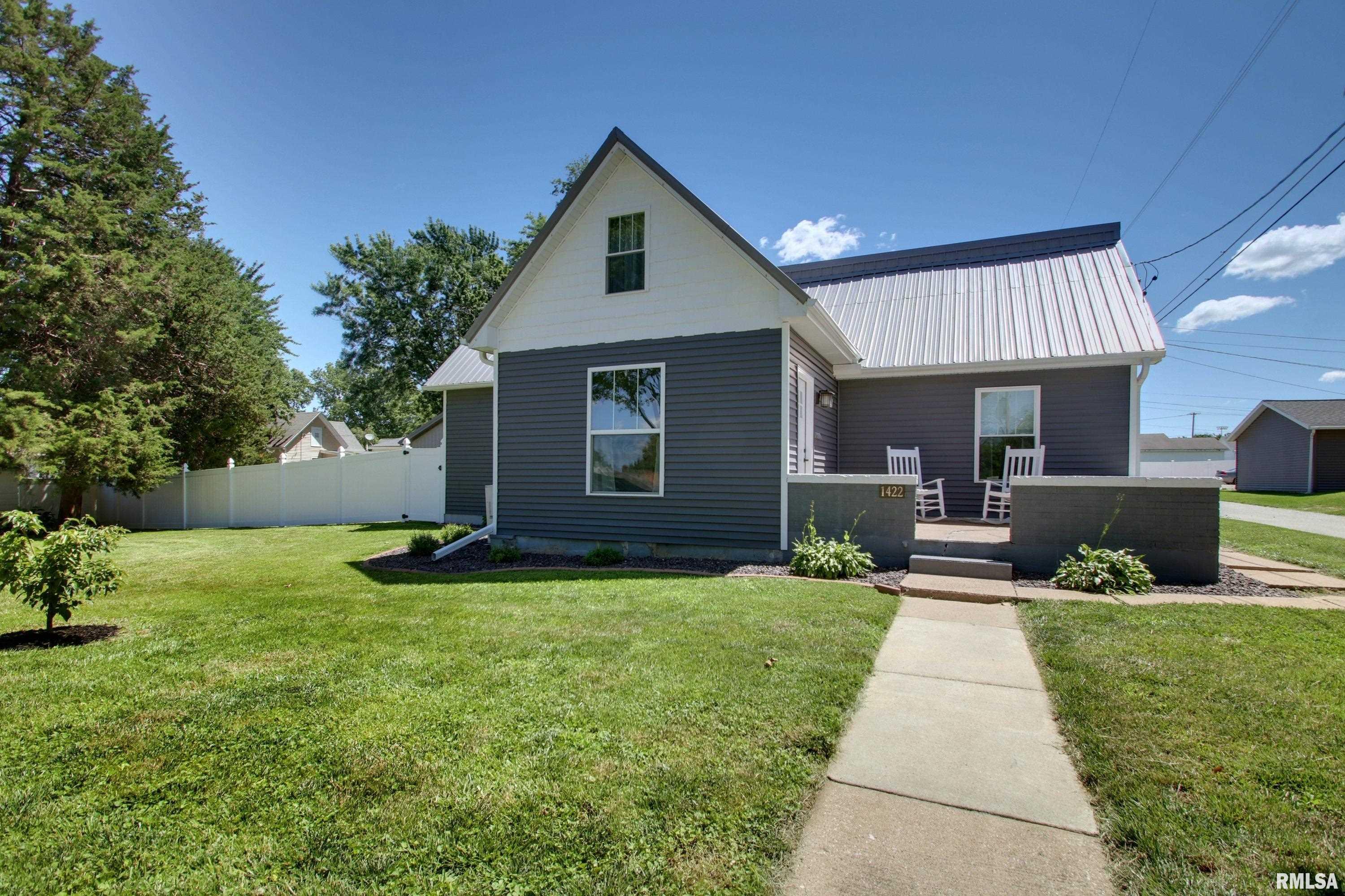 Offered for the first time in approximately 76 years, this extensively renovated property combines timeless character with the peace of mind of major modern updates. Thoughtfully rebuilt and improved in 2017, updates include a metal roof, siding, replacement windows, electrical, plumbing, HVAC, water heater, and a spacious second-floor primary suite addition. Original hardwood floors have been professionally refinished, preserving the home's charm while complementing today's lifestyle. The primary suite features a private door leading to the porch awning, which was intentionally constructed with plywood beneath the metal roof to support a potential future outdoor sitting area. Add a railing and create your own elevated retreat to enjoy morning coffee, evening sunsets, and seasonal fireworks. A rare opportunity for car enthusiasts, hobbyists, contractors, collectors, or small business owners. The impressive 28' x 40' open-span outbuilding offers natural gas and water hookups, providing endless possibilities for storage, projects, equipment, vehicles, or future customization. In addition, the detached 2-car garage features a workshop area and an in-ground service pit, making maintenance and repair projects more convenient. Outside, enjoy a beautifully maintained fenced backyard with manicured landscaping and room to relax, entertain, garden, or play. Properties offering this level of renovation, garage space, workshop functionality, and pride of ownership are rare.