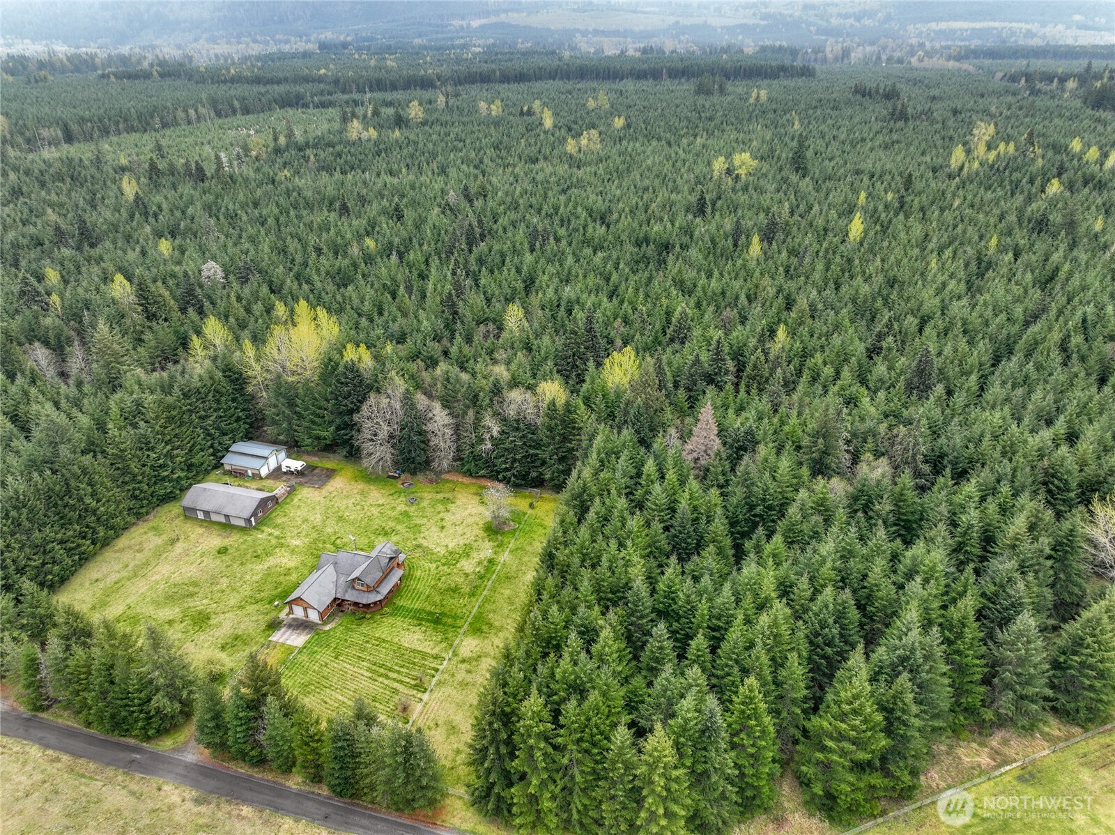 Tucked away on a private dead-end road in Randle, this custom cedar home offers the perfect Pacific Northwest retreat on large, usable acreage. Surrounded by towering evergreens, the setting delivers a rare blend of privacy, sunshine, and mountain serenity.Inside, you’ll find warm wood accents, vaulted ceilings, and spacious living areas filled with natural light. The home features 3 bedrooms and inviting gathering spaces, including a bright living room with large picture windows overlooking the grounds.Step outside to enjoy a covered wraparound porch—ideal for year-round relaxation—and a fully usable property ready for animals, gardening, or recreation. Multiple outbuildings include a large detached shop and barn, offering endless flexibility for hobbies, storage, or small-scale farming.Located just minutes from Lake Scanewa and the Gifford Pinchot National Forest, this property is a gateway to hiking, fishing, boating, and year-round outdoor adventure.Privacy, space, and Northwest beauty—this is the lifestyle you’ve been looking for.
