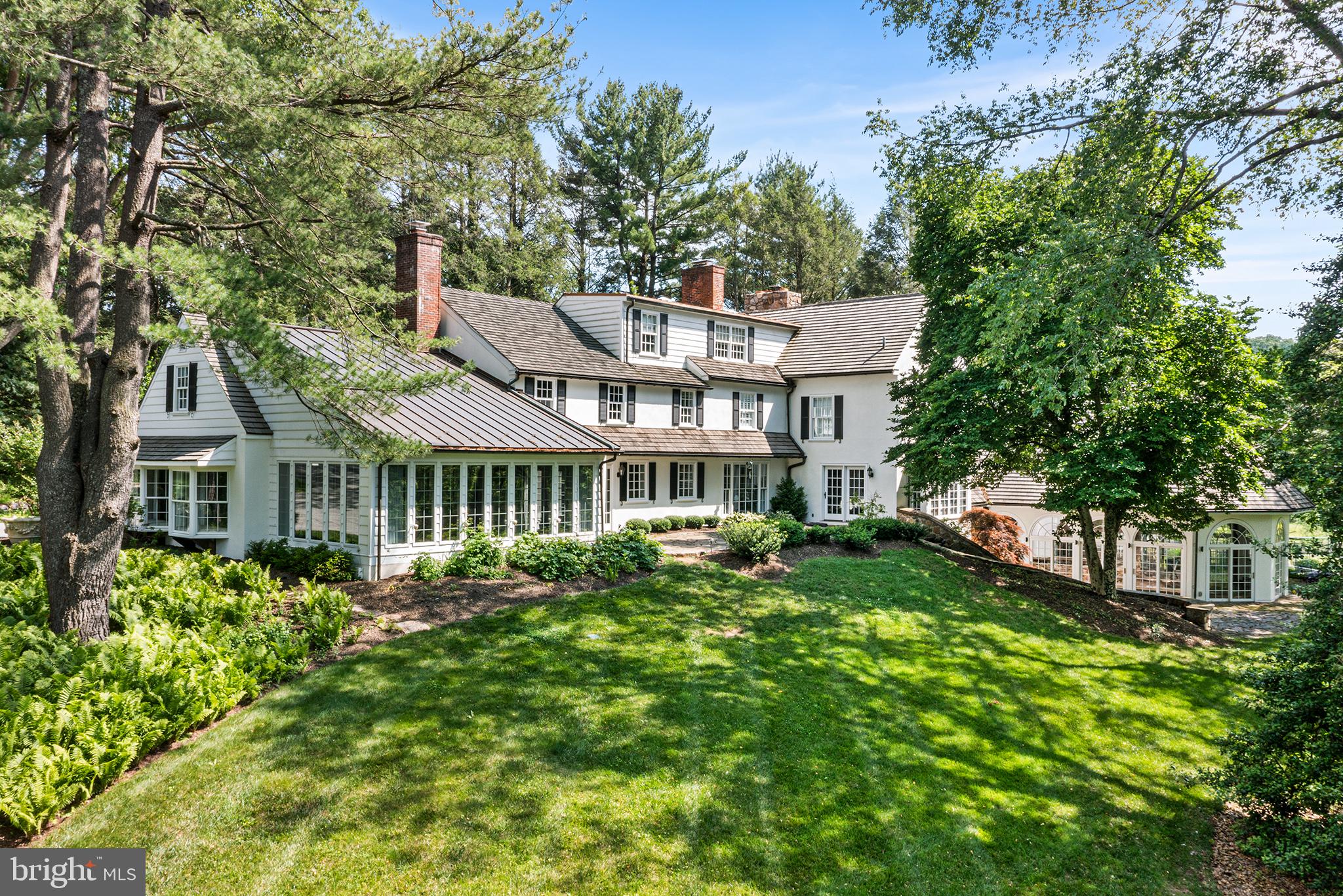 Welcome to 2490 White Horse Road.  "Meadowmist" is a fully renovated, classically and elegantly designed 4 bedroom traditional style home sited on the highest elevation of six picture-perfect acres on one of Easttown Township's most coveted winding country roads.  Privacy abounds as the house is approached up a long driveway to the back of the lot. "Meadowmist" truly combines luxurious living with breathtaking scenery. Additional supporting structures include a 3 car detached garage with upstairs heated and air conditioned living space and a full bath, a small 2 stall stable, a garden shed and a fenced tennis / basketball / sport court.  A discreetly placed indoor swimming pool with attached spa room rounds out the resort feel of Meadowmist. No detail was overlooked in the home’s recent transformations, from high-end finishes and designer touches to upgraded "smart" features. Enter through a covered stoop into a sweeping two-story formal entrance. One will immediately feel the comforts of home by gleaming hardwood floors, custom millwork, neutral paint, abundant windows with luxurious treatments, designer light fixtures, a state-of-the-art Lutron® lighting system and three fireplaces. The sunlit dining room features a wood burning fireplace, bespoke glass cabinetry and beautiful countryside views. The chef's kitchen boasts a large center island, white inset cabinetry with marble countertops, Subzero® and Thermador® appliances and a walk-in pantry.  The inviting large family room's custom built-ins will delight, providing a casual yet elegant family and friends gathering space with gas fireplace.  Direct access to a panoramic sunroom-dining space with heated synthetic slate floors, coffered-beadboard ceiling and expansive views of the rolling acreage.  A graciousliving room, also with gas fireplace and a private office with custom built-ins, expanded laundry suite, and half bath complete the first floor. Upstairs, the primary suite includes every upgrade and amenity imaginable, from a separate sitting room with window seat and custom built-ins to designer his and hers walk-in closets. The spa-like ensuite bath features a soaking tub beneath a tall arched window, dual vanities, water closet, heated floors and oversized shower with bench.  The second bedroom has a large sitting room/office space with built-ins and hall bath and the third bedroom has a renovated ensuite bath.  The third floor houses the expansive fourth bedroom suite with lounge and renovated bath, and extra storage. The lower level is a wellness haven anchored by a freshly painted, windowed pool house with beamed ceiling andstone accents, lap lane, hot tub, new sauna and a meditation room with oversized full bathroom with steam shower.  An adjacent kitchenette and lower-level finished rec room add convenience and versatility.  There is an auto lock keypad for both entrances to pool / spa area providing extra security & peace of mind. Outside, enjoy a multi-tiered stone terrace, discreetly sited tennis and basketball/sport court and secondary hot tub. The entire second floor above the detached three-car garage with a full bath andkitchenette is the perfect in-law suite, 5th bedroom  or home office. Located in top-rated T/E School District and is just minutes from all the Main Line has to offer including Amtrak (Paoli) and Local R5 train service. Continue along White Horse Road to the 90 Acre Kirkwood Preserve for a truly Country experience with mowed walking trails.  This majestic estate exudes luxury and natural beauty at every turn in a fabulous location.