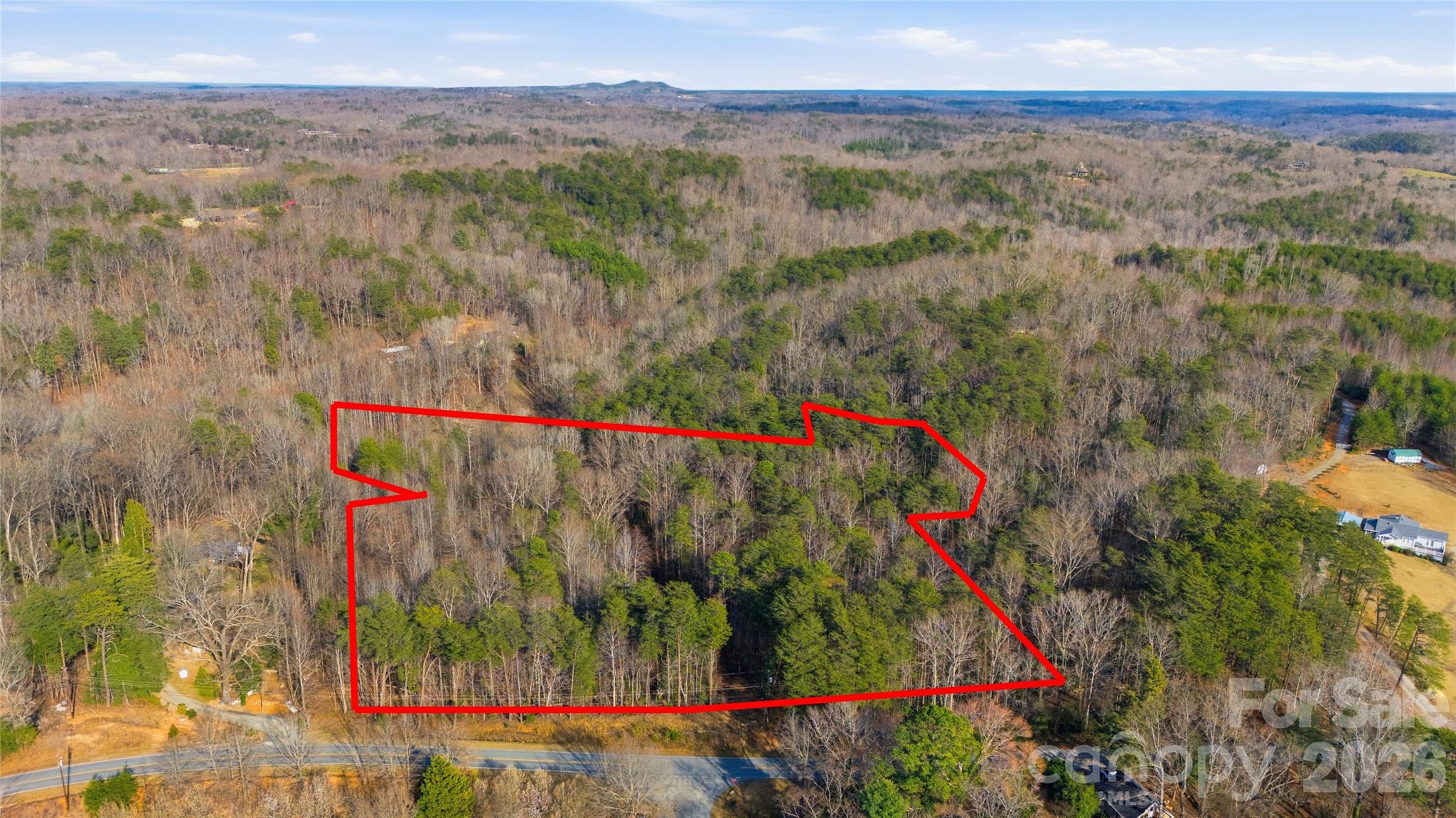 Rare opportunity to own 14.5 acres of unrestricted wooded land in the foothills in Tryon, NC —perfect for a private homesite, mountain retreat, or homestead.Located on Hooker Road near the charming towns of Tryon, Landrum, and Columbus, this beautiful tract offers both privacy and convenience in one of the most desirable areas of the Carolina foothills. Whether you are looking to build a custom home, create a peaceful getaway, or invest in land with long-term potential, this property offers the flexibility and space to bring your vision to life.The parcel features approximately 600 feet of road frontage on Hooker Road, providing excellent access and multiple potential building locations. The property is fully wooded, offering natural privacy, mature trees, and a peaceful setting filled with wildlife and natural beauty. With over fourteen acres to explore, there is plenty of room for trails, gardens, recreational space, or a secluded homesite tucked into the landscape.One of the standout features of this property is that it is unrestricted, giving buyers the freedom to use the land without HOA regulations or restrictive covenants. This flexibility makes the property ideal for a variety of possibilities including a custom home, mountain retreat, small farm, or property with homestead potential.Conveniently located just minutes from the restaurants, shops, and small-town charm of downtown Tryon, the property also offers easy access to Landrum and Columbus, with Spartanburg and Asheville within comfortable driving distance. Enjoy the peaceful setting of the Carolina foothills while still being close to everyday conveniences.Large tracts of unrestricted land in this area are becoming increasingly difficult to find, making this a wonderful opportunity for buyers seeking privacy, natural beauty, and future potential.