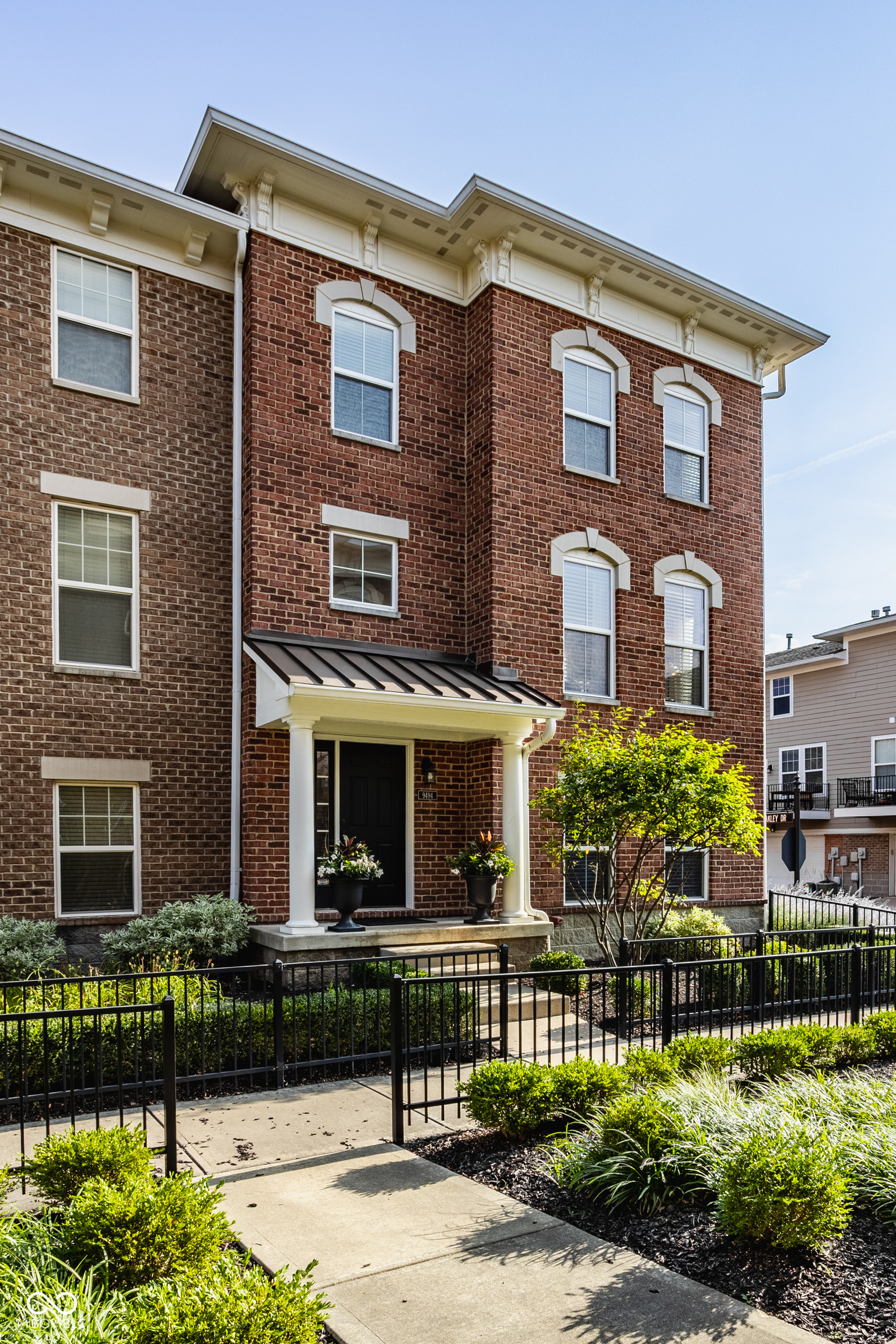 Low-maintenance living meets exceptional space, privacy, and convenience in this brick end-unit townhome in Park Meridian, just minutes from downtown Indianapolis, Carmel, and the Monon Trail. Windows on three sides fill the home with natural light, while adjacent mature landscaping provides privacy rarely found in townhome living. Enjoy morning sun from the east-facing windows and unwind on the private balcony with updated decking-perfect for relaxing. Custom wall trim details and wrought-iron staircase balusters add architectural character from the moment you enter. The open main level is designed for entertaining, with hardwood floors connecting the expansive living room, open-concept kitchen, and hearth room with a gas fireplace, currently used as a dining room. The kitchen features a large center island, newer built-in appliances, abundant cabinetry, and direct access to the balcony for seamless indoor-outdoor living. Upstairs, the third level includes the light-filled primary suite offering a refreshed ensuite bath and spacious walk-in closet, while two additional bedrooms, a full bath, and conveniently located laundry provide flexibility for guests or a home office. Zoned heating and cooling helps keep each level comfortable year-round. The finished lower level expands your living space with 9-foot ceilings, surround sound, and a full bath-ideal for a second family room, media space, home office, fitness room, or private guest retreat. Recent updates include a refreshed primary bath with new quartz top, fresh paint, updated lighting, newer built-in kitchen appliances, updated balcony decking, and a newer water heater. All kitchen appliances stay. The HOA covers lawn care, landscaping, snow removal, and exterior siding maintenance, giving you more time to enjoy nearby shopping, dining, Holliday Park, Town Run Trail, the Monon Trail, and easy access to Meridian Street, I-465, downtown Indianapolis, and Carmel.