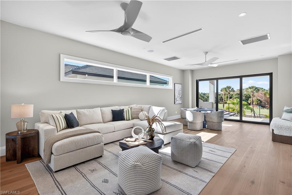 Living room with wood finished floors, a ceiling fan, and recessed lighting