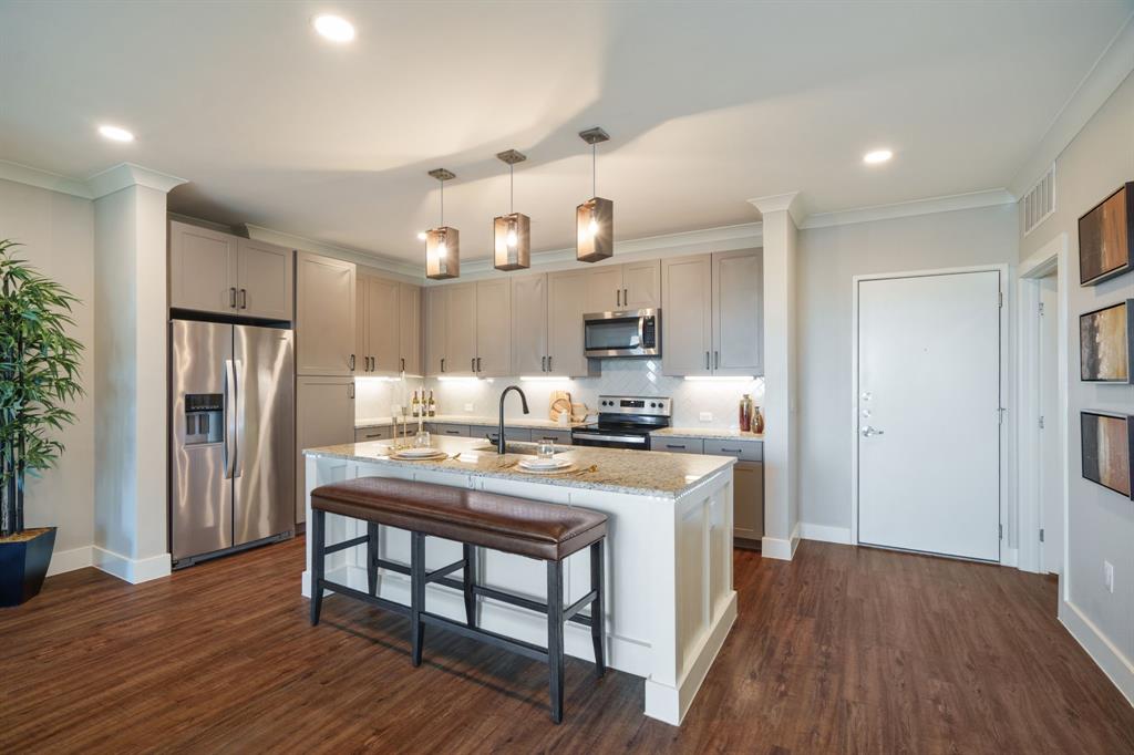 When location matters, this stunning condo is in the perfect spot! Live life on the top floor of this 5 story condo located minutes to Grandscape, shopping, fine dining, Stonebriar Mall, Legacy West, and major corporate headquarters. True lock-and-leave living with secure entry, attached garage, indoor community mailboxes and elevator. North facing entry steps into a modern open floorplan where inviting friends and family to visit is must! The Living room is anchored by a VOICE ACTIVATED CUSTOM FIREPLACE WALL with elegant stone from floor to ceiling. Natural light floods in through the private patio doors where you can enjoy morning coffee or evening beverages while relaxing. The flow of the floorplan pulls you into the well sized kitchen with stainless steel appliances, ample storage, under counter lighting, and elegant island. You will be thrilled that the refrigerator, washer, dryer, and TV mounts convey with acceptable offer. The patio grill is available for purchase, too! This unit comes with attached to building garage space#132, additional temperature controlled storage unit directly in front of garage space#36, and carport with upgraded exterior lights is #15. Everything you need is at your fingertips! The split bedroom layout allows for plenty of privacy. Just admire all the fixtures and added features that make this 'the one'. From the layout, to the community of neighbors, and convenient location, you will love your new place to call home! The HOA even has a resident app for communication.