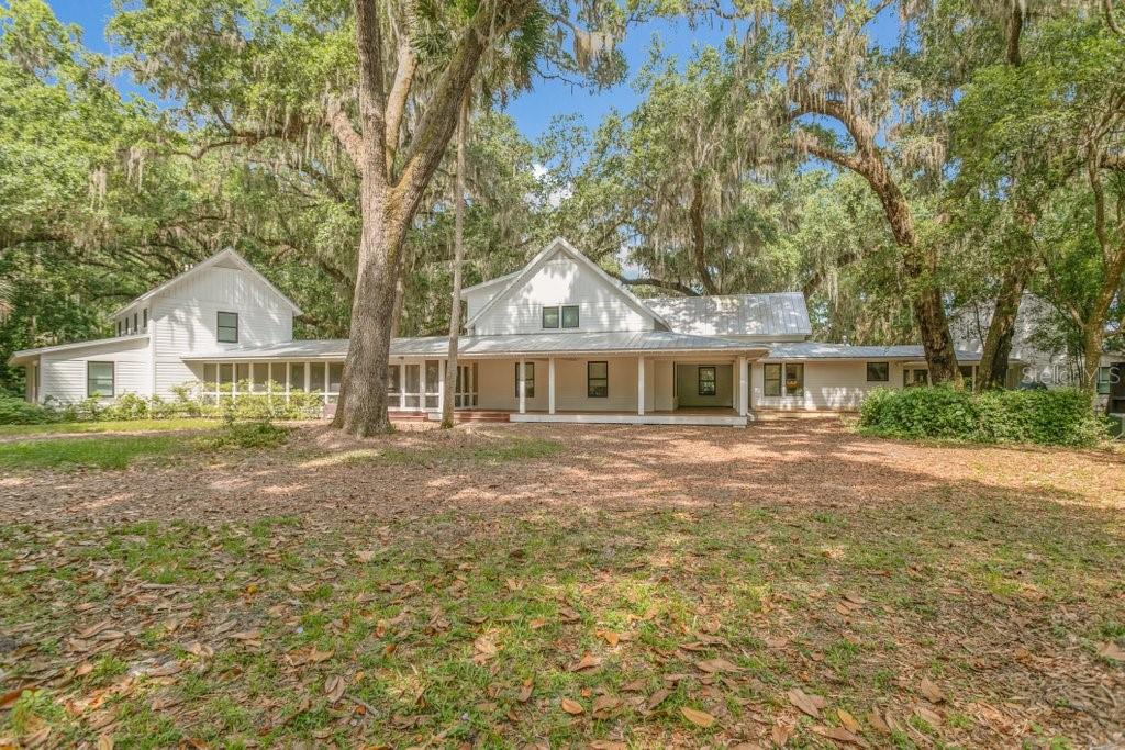There are properties, and then there are places that feel like they were always meant to exist —rooted in the land, shaped by the river, built for a life lived slowly and well. This is one of those places.Situated on 20.2± acres of unspoiled North Florida terrain across two contiguous parcels, this extraordinary riverfront compound commands 423 linear feet of St. Johns River frontage — one of the most coveted stretches of private waterway in the state. The grounds unfold with quiet intention: a working barn anchors the back acreage, mature hardwoods and native landscape frame the approach, and beyond the compound, the land remains beautifully undeveloped.Designed by HAASE DESIGN of Melrose, FL — an award-winning, father-and-son studio with a signature reverence for Old Florida vernacular — and brought to life by Olson Construction, the main house spans approximately 5,500 square feet of ICF-constructed, timber-truss, vaulted-ceiling living space across an open, airy floor plan with 3 bedrooms and 2.5 baths. Two guest cottages, each offering 3 bedrooms and 2 baths, complete the compound. All three structures are seamlessly connected by roofed, screened breezeways — no steps, no interruptions, just a fluid flow between indoor and outdoor living.The porches and outdoor spaces are where this estate truly breathes. Morning coffee in the screened breezeway. Afternoon shadows crossing the grounds. And then the river — always the river — drawing you toward the two-story permitted dock with boat lift and 360-square-foot sundeck, where world-class St. Johns River bass fishing awaits and sunsets arrive like slow paintings across the water.Aerial views reveal what photographs cannot fully capture: the scale of the riverfront, the sweep of the acreage, and the harmony of a compound that feels both grand and deeply personal.
