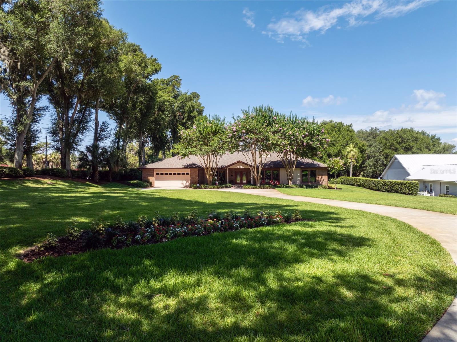 OUTDOOR LIVING, ONE-STORY COMFORT & IN-TOWN WINDERMERE LIFESTYLE COME TOGETHER AT THIS RARE 1.27-ACRE WINDERMERE OAKS PROPERTY. Set within the TOWN OF WINDERMERE, this beautifully maintained one-story pool home offers privacy, space & the lifestyle buyers hope to find, with NATURAL GAS, mature landscaping, a PARTIAL BUTLER CHAIN LAKE VIEW, and exceptional outdoor living that feels like a true extension of the home.The screened pool area is the heart of the property, beautifully finished with brick pavers & designed for everyday enjoyment as well as memorable entertaining. The 35' X 20' IRREGULAR-SHAPED POOL is complemented by multiple water features, a separate step-in spa with bubbler, a custom firepit, and a highly functional summer kitchen with bar seating, grill, ice maker & refrigerator. With approximately 812 SQ FT OF OPEN FINISHED PORCH/LANAI AREA, including a main lanai approximately 62' X 12', there is room to dine, gather, relax, watch the game, host friends, or simply enjoy the peaceful setting in every season.The PRIMARY SUITE is a true highlight of the home, privately positioned and beautifully finished with a spacious bedroom, direct access to the outdoor living area, and a STUNNING PRIMARY BATH that feels calm, elegant & luxurious. Thoughtful details, generous closet space, quality finishes, and a retreat-like feel make this suite stand apart.Inside, the home offers a warm, livable floor plan with NO STAIRS & generous gathering spaces. The main living areas connect comfortably to the outdoor spaces, creating an easy flow for entertaining & everyday life. The kitchen is positioned at the center of the home with generous prep & storage space, natural gas cooking, and a connection to the main living & dining areas that keeps everyone together. Additional bedrooms & flexible rooms provide options for guests, work, hobbies, fitness, or multigenerational living. The ONE-STORY design offers long-term comfort & convenience without sacrificing space or privacy.The setting is what makes this property so special. With 1.27 ACRES inside the Town of Windermere, there is a sense of privacy & breathing room that is increasingly hard to find. Mature trees, established landscaping, and a long residential feel create a peaceful backdrop, while the partial lake view adds a lovely connection to the Butler Chain lifestyle without making the home solely about the view.Life in WINDERMERE OAKS means you are close to the charm of downtown Windermere, weekly farmers markets, community events, local parks, brick streets & the small-town character that makes this area so loved. You are also minutes from top schools, shopping, dining, major roadways & Central Florida attractions, making the location as practical as it is beautiful.This is the kind of Windermere property buyers hope to find but rarely do: 1.27 private acres, ONE-STORY LIVING, NATURAL GAS, exceptional outdoor living, a beautiful PRIMARY SUITE, a PARTIAL BUTLER CHAIN LAKE VIEW, and a setting that makes home feel like the best place to be. It invites you to slow down, gather often, celebrate outside & enjoy the lifestyle that makes the TOWN OF WINDERMERE so special.