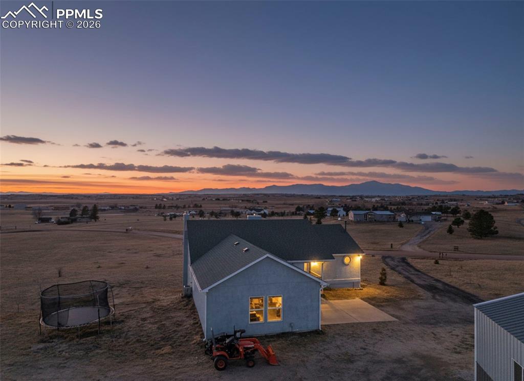 INCREDIBLE MOUNTAIN VIEWS! Discover the perfect blend of space, functionality, and Colorado living in this expansive 4-bedroom, 3-bathroom home offering over 3,000 square feet of finished living space on 5 beautiful acres in the highly desirable Peyton area. 8 minutes to Walmart and major shopping corridor. Designed for both comfort and versatility, the home features spacious, light-filled living areas, scenic mountain views, and a well-balanced floor plan that provides privacy while maintaining an easy flow for everyday living and entertaining.The primary suite serves as a true retreat, featuring French doors that open to the deck where you can take in sweeping mountain views, along with an attached bathroom. Additional bedrooms are generously sized and flexible—ideal for family, guests, or home office use. Whether hosting gatherings or enjoying quiet evenings at home, this layout adapts effortlessly to a variety of lifestyles.Significant upgrades enhance both comfort and peace of mind, including a whole-house water filtration system and a new Class 4 impact-resistant roof installed in 2023. Outside, the property has been thoughtfully improved with extensive landscaping, featuring numerous newly planted trees supported by an irrigation system, creating a private and inviting outdoor setting with room to grow.A true standout feature is the impressive 48’ x 35’ insulated shop, complete with permitted electrical service, perfect for hobbyists, mechanics, storage, or a dedicated workspace. An RV outlet further adds to the property’s exceptional versatility, making it ideal for those with recreational vehicles.Enjoy the peace and openness of country-style living while remaining conveniently close to Colorado Springs, military bases, shopping, and schools. With ample space to live, work, and play, this property delivers the rare combination of acreage, upgraded infrastructure, and functional outbuildings that today’s buyers are actively seeking.