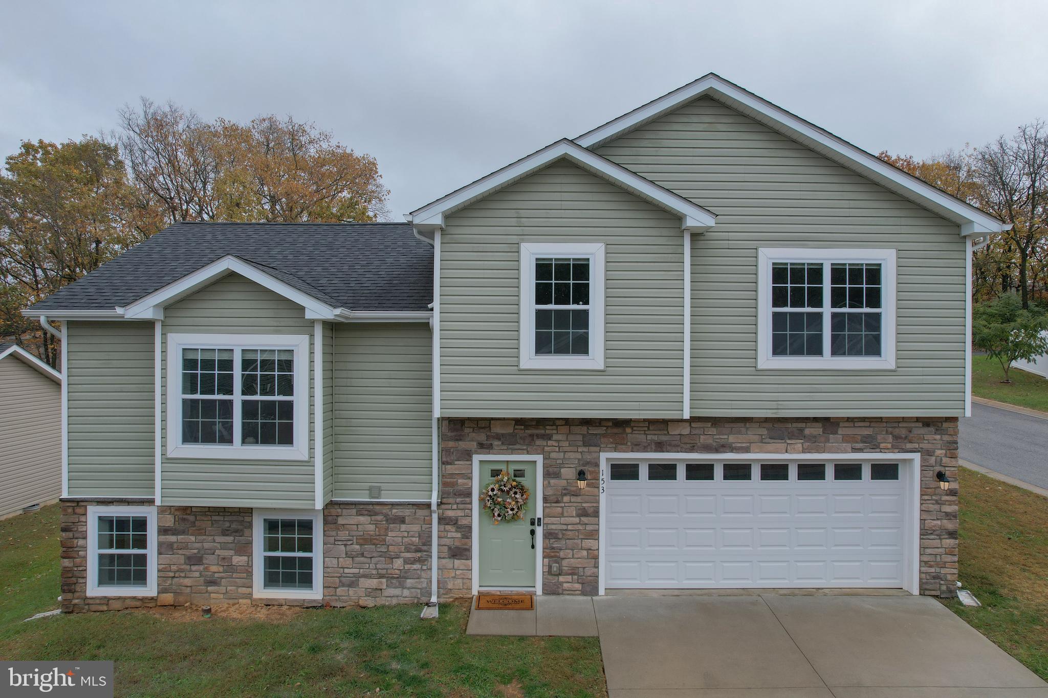 Come and see this Move-In Ready Split-Level Home with 3 Bedrooms, 3 Baths,  Built 2019 conveniently located in Inwood, WV.Why wait for new construction when you can have like-new right now? Built in 2019 by a reputable local builder known for enduring quality, this beautiful split-level home blends modern design with everyday functionality—set on a corner lot in a peaceful community just minutes from Inwood conveniences.Step inside the tiled entry foyer, where a spacious laundry room and access to the two-car garage make day-to-day living effortless. The fully finished lower level features a large flex room with natural light, plus a full bathroom with walk-in shower and vanity—perfect for guests, hobbies, or multi-generational living.Upstairs, the open-concept main level boasts luxury vinyl plank flooring, fresh paint throughout, and an inviting kitchen with granite countertops, island with bar seating, soft-close white cabinetry, and stainless steel appliances. Sliding doors lead to a deck overlooking the backyard—ideal for relaxing or entertaining.The upper level offers three generously sized bedrooms, including a primary suite with tray ceiling, double closets, and a private ensuite bath featuring a walk-in shower and double vanity. Two additional bedrooms provide ample closet space and share a bright hall bath.Additional highlights include new carpet throughout bedrooms, a power-washed exterior, and blinds that convey. Enjoy country views while staying close to commuter routes, shopping, and schools—this Arden Nollville area gem offers the best of both worlds.