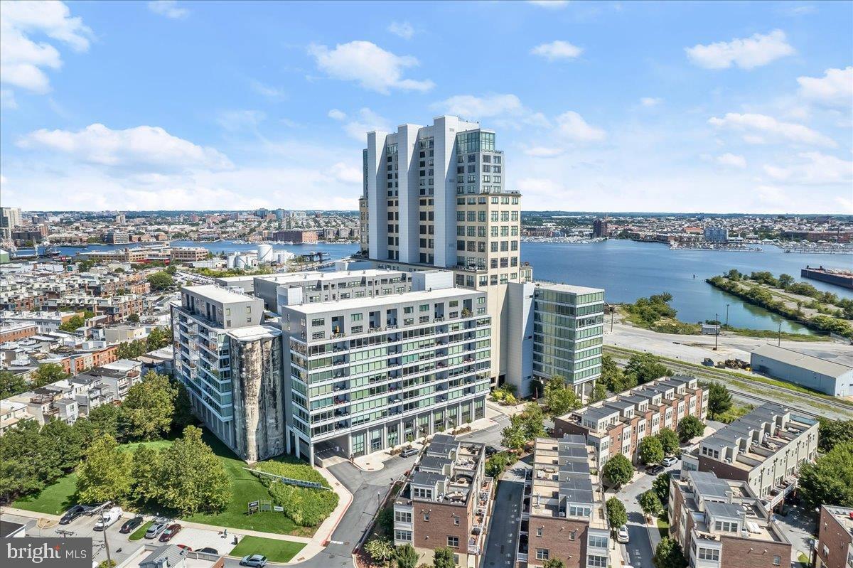 Experience elevated waterfront living at its finest in this beautifully renovated residence at Silo Point, Baltimore's iconic luxury condominium in the heart of Locust Point. Offering over 1,300 square feet of sophisticated living space, this exceptional one-bedroom, one-and-a-half-bath home combines modern elegance, breathtaking panoramic views, and unparalleled amenities. Step inside to discover soaring 9+ foot ceilings, expansive floor-to-ceiling windows, and an open-concept design bathed in natural light. Automated window shades allow you to effortlessly frame spectacular city and water views while enjoying unforgettable sunsets from the comfort of your home. The gourmet kitchen is thoughtfully designed with granite countertops, stainless steel appliances, a decorative backsplash, an oversized center island with breakfast bar seating, and abundant cabinetry, creating the perfect space for everyday living and entertaining. The spacious living and dining areas flow seamlessly together, maximizing the home's open feel and showcasing the incredible views beyond. The luxurious primary suite serves as a private retreat, complete with a generous dressing area, two closets, including a walk-in closet, and a fully renovated spa-inspired en-suite bath featuring a dual-sink vanity and an expansive walk-in shower. A stylish powder room provides added convenience for guests. Recent improvements include hardwood flooring, updated appliances, and a beautifully renovated primary bathroom, making this residence truly move-in ready. Residents of Silo Point enjoy an unmatched collection of resort-style amenities, including: 24-hour concierge and front desk service, On-site professional property management, State-of-the-art fitness center, Renovated 19th-floor Sky Lounge with breathtaking harbor and city views, Conference and meeting rooms, Game room and library, Wi-Fi throughout the lobby and Sky Lounge, Pet-friendly amenities, Three assigned parking spaces, Located in the highly desirable Locust Point neighborhood, you're just moments from Fort McHenry National Monument, Tide Point, Latrobe Park, the Baltimore Peninsula, waterfront promenades, restaurants, breweries, and boutique shopping. Enjoy easy access to the Water Taxi, Downtown Baltimore, the Inner Harbor, and major commuter routes including I-95, I-295, I-395, I-695, and I-895, providing convenient access throughout the region. This extraordinary home offers the perfect blend of industrial-chic architecture, modern luxury, breathtaking views, and an exceptional waterfront lifestyle, making it one of Baltimore's most sought-after condominium residences.
