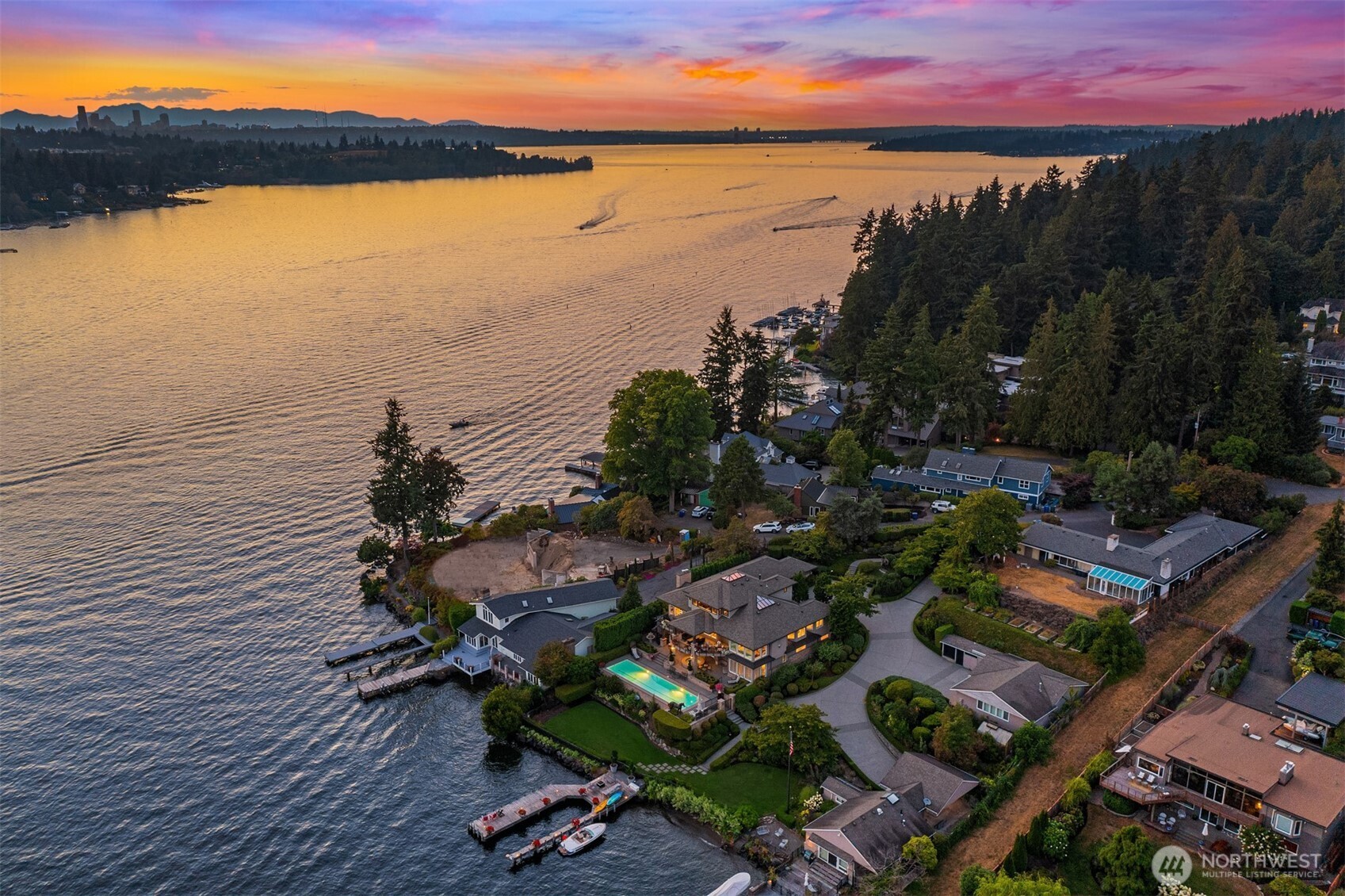 It's waterfront time! Drive down your private, gated drive to a stunning waterfront retreat sited on 74 ft of sunny southwestern frontage. This grand home offers poolside living and entertaining lakeside while highlighting dazzling Mt. Rainier views and spectacular sunsets overlooking Lake Washington's east channel. A substantial dock has a protected slip and lift providing plenty of space for all of your water toys. Stunning black and white marble floors are a WOW as you enter creating an air of urbane sophistication. A soaring skylit entry hall draws you into light filled generous day rooms.The reimagined chef’s kitchen will thrill even the most discerning and boasts the latest  “must have” for serious cooks, a separate prep kitchen.