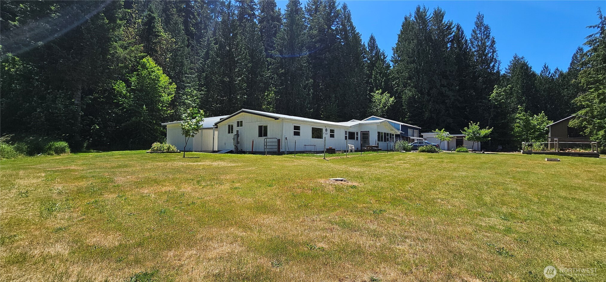Set on 3.671 private acres, this beautiful home offers the perfect blend of open lawn, forest backdrop, and peaceful territorial views right out the front windows. The front and back lawns create a welcoming, park like setting, while the forested edge behind the home adds privacy and a sense of retreat.  A two space carport provides covered parking with direct access to both the shop and the backyard. The property also includes a woodshed and two additional storage sheds — one fully insulated for cool storage, ideal for food preservation or temperature sensitive items.  Inside, the home features a large laundry room, an inviting open kitchen, and a comfortable living room warmed by a wood burning stove for quiet evenings at home. The floor plan places the main bedroom at one end of the home for privacy, with additional bedrooms at the opposite end, making it a great layout for guests.   If you’re a handy person, welder, auto mechanic, or woodworker, this property is a dream. The two bay shop spans over 1,000 sq ft, fully insulated and wired for machinery and welding. It includes a full attic storage area with stair access, giving you room for tools, projects, and equipment without compromise.  This property offers space, privacy, functionality, and the freedom to create — all in a serene natural setting.