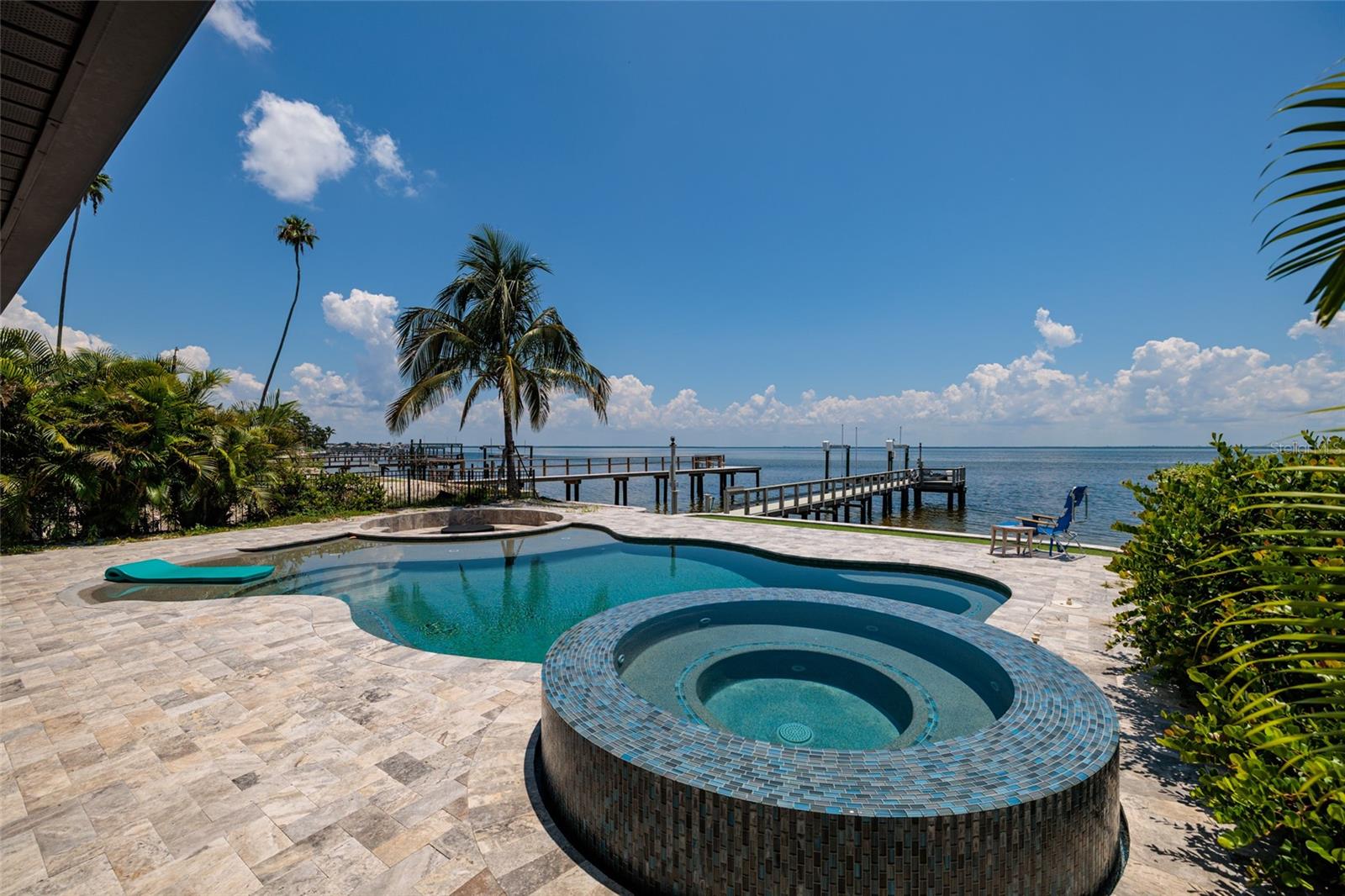 Welcome to this spectacular open water estate on Bayshore Boulevard Northeast, offering unparalleled views of Tampa Bay and showcasing the pinnacle of luxurious coastal living. Situated on nearly a quarter-acre lot, this fully "REMODELED" and "FURNISHED" three-bedroom, three-bath home with an office and an oversized two-car garage is the ultimate waterfront retreat. Enjoy breathtaking bayfront vistas from nearly every room, and step outside to a brand-new pool and spa area with an outdoor kitchen, fire pit, and expansive screened-in patio—perfect for entertaining or relaxing in total serenity. Inside, the home has been completely transformed with high-end finishes throughout. The custom kitchen features sleek blue cabinetry, quartz countertops, stainless steel appliances, and opens to the living and dining areas, creating an ideal flow. All three bathrooms have been beautifully renovated, and the entire home is adorned with new luxury vinyl plank flooring, designer lighting, fresh paint inside and out, and stylish accent walls that elevate the space. Additional features include two brand-new HVAC systems, a full hurricane impact windows and sliders, and a private elevator providing easy access from the living area to the stunning upstairs primary suite. The primary bedroom offers its own access to the second-floor balcony with panoramic views, while the first floor boasts an inviting office with built-in shelving, an indoor laundry room, and loads of storage. A newer dock with power, water, and a boat lift completes the waterfront lifestyle package. Located just minutes from downtown St. Pete, the Vinoy Golf Club, local beaches, top-rated dining, nightlife, and shopping, this premier location also offers quick access to both St. Pete–Clearwater Airport (15 minutes) and Tampa International Airport (20 minutes). This is truly one of the most coveted streets in St. Petersburg, combining elegance, function, and jaw-dropping bay views. Call to schedule your private tour today—you won’t be disappointed.