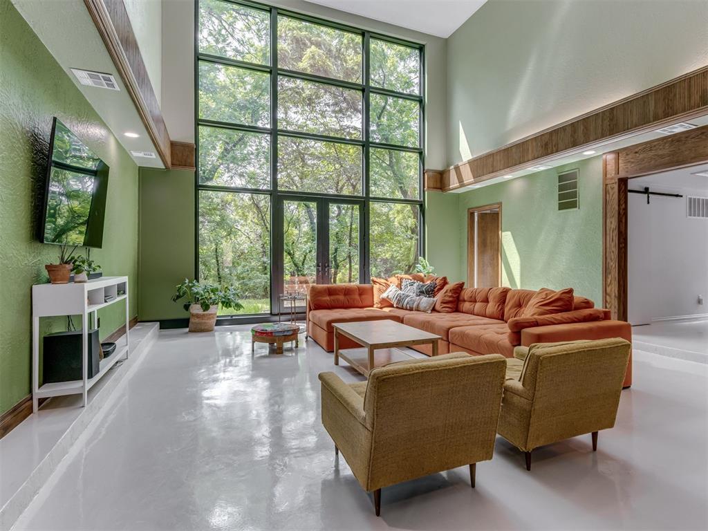 Tucked away down a long winding road you will find an amazing renovation surrounded by a lush wooded 5 acre lot, with the feeling of seclusion and privacy yet still in the heart of OKC. Such a fun yet elegant style of Mid century modern, This spacious home does not disappoint with impressive soaring ceilings and amazing views.  The unique split staircase at entry, will lead you up to spacious primary bedroom with large walk in closets and a truly breathtaking spa like en suite bathroom. At the other side of staircase/open hall balcony you will find two other large bedrooms with walk in closets and are connected by a rare true jack and jill style bathroom complete with 2 sinks & vanities, 2 separate toilets and tons of storage with shared bathtub/shower. There is also a “walk-through” room that leads into one of the bedrooms, (3rd upstairs bedroom option or office) from here you can climb up to the loft that makes the perfect fun game room for the kids.
Head down either side of split staircase and you will find yourself on the landing that overlooks the substantial great room with an amazing view of the lush wooded back yard, framed in floor to ceiling Pella windows.  This tremendous living space opens up to luxurious kitchen and dining area with gorgeous quartzite countertops, large pantry, ample storage and natural light. Off the dining room you can step outside onto a large deck that is perfect for gatherings and entertaining. 
Downstairs to the left of front door entry, another bedroom with its own full bath and additional entrance to/from the hall, perfect for guests. To the right of entry another large bonus room, perfect for den, office or library. Additionally there is another room downstairs with indoor storm shelter/safe room. This space can also be used for storage, workshop, or hobby room.
This home has so many unique details, upgrades and possibilities, the photos truly let this property speak for Itself, schedule soon to see in person!