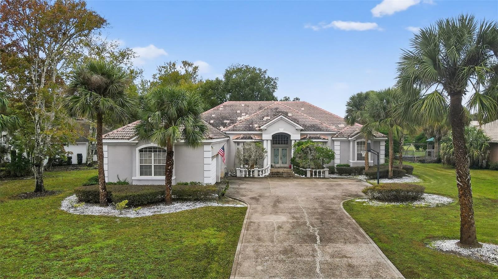 Auction Property. Set on a spacious lot surrounded by mature palm trees and manicured landscaping, this elegant Lake Mary residence offers classic Florida curb appeal in one of the area’s most desirable communities. The sweeping circular-style driveway and impressive three-car garage create a grand arrival, while the stately front elevation, columned entry, and high-arched windows set the tone for a home designed for both comfort and presence.The exterior features timeless architecture and a tiled roof, complimented by clean, low-maintenance stone accents and well-kept greenery. Large front and side yards provide ample outdoor space, offering the flexibility for gardening, play areas, or future enhancements.Located in the heart of Lake Mary, this home places you minutes from top-rated Seminole County schools, Publix, Target, Colonial Town Park, restaurants, golf courses, walking trails, and quick access to I-4 and the 417 for seamless commuting. Enjoy the convenience of nearby shopping and dining, weekend markets, and all of Lake Mary’s renowned lifestyle amenities.This property presents an exceptional opportunity to enjoy spacious living in a sought-after, beautifully established neighborhood with unbeatable proximity to everything Lake Mary has to offer.