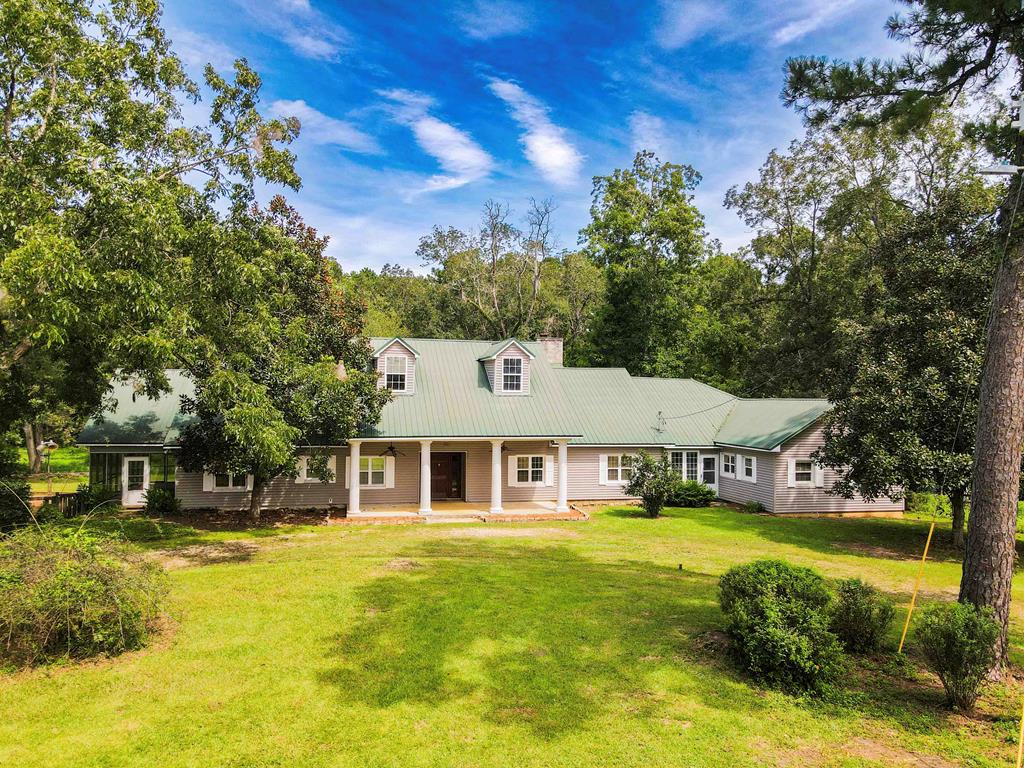 Nestled just 2 miles from Thomasville, this extraordinary 4500 sqft, 5-bedroom, 4-bath estate offers the perfect blend of country living with the convenience of town. Set on a picturesque 10.7 acres, this property presents a unique opportunity to own a spacious home with abundant land—something rarely found so close to Thomasville. The home itself is two residences in one. The main house features an expansive 3 bedroom 2 bath layout, highlighted by a massive kitchen with room for entertaining and dining. The oversized living area offers plenty of space for gatherings, family time, or relaxation. Connected to the main home is a separate 2 bedroom 2 bath apartment with its own private entrance, full kitchen, and laundry room. Whether you envision it for guests, extended family, or even as an income-generating rental, the possibilities are endless. It could also be transformed into a massive master suite. Outside, the land is just as impressive. Several acres of mature, producing pecan trees provide both beauty and bounty. For horse enthusiasts, a large, fenced pasture is ready for your horses or livestock, offering ample room for them to roam. The back of the property is wooded and alive with nature, where deer and turkey frequently pass through, creating a serene and peaceful atmosphere right in your backyard. The property also includes a pool, which is ready for refurbishment, giving you the chance to restore it to its former glory or reimagine it as the ultimate outdoor oasis. Though the home itself is in need of some updating and remodeling, its incredible size, dual-living setup, and vast potential make it a dream canvas for anyone looking to personalize their forever home. This is a rare gem, combining generous acreage, two homes, and proximity to town. If you're searching for a property with endless potential and the space to make your vision a reality, this is the one.