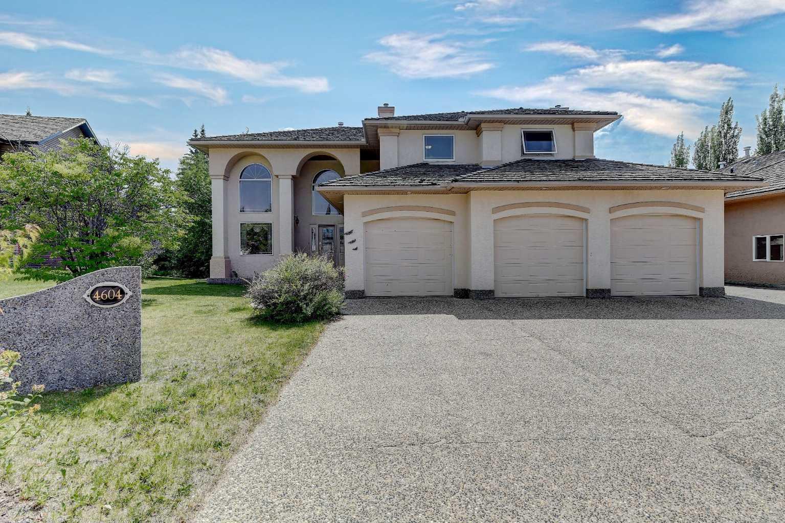 QUICK POSSESSION on this Wedgewood Home is 2556 sq ft that backs onto a serene wooded ravine and features a landscaped yard, developed basement, and a heated triple garage with extra RV parking. Step inside to a bright, open layout flooded with natural light through south facing windows. The kitchen boasts stainless steel appliances, an island with counter top stove, tile backsplash, ample cabinetry, generous counter space, and a walk-in pantry. The balance of the main floor offers a spacious family room with gas fireplace, formal dining area, a convenient den with glass doors, half bath, and a laundry room complete with sink and cabinetry. Upstairs, retreat to your massive primary suite featuring a three-sided fireplace, jetted tub, walk-in closet, and a private balcony. Two additional large bedrooms and a full bathroom complete the upper level. Two story high ceilings in foyer and den creates an open feeling. The fully finished basement is designed for both relaxation and entertainment, with a large family room, bar area, workout space, gas fireplace, bedroom, and full bathroom. Enjoy year-round comfort with a heated triple garage, and entertain with ease in the large backyard complete with a large 2 year old deck, fire pit, sitting area, a previously used rock fish pond area, sprinkler system, and picturesque ravine views. Contact your real estate professional for private viewing. Make this home your own.