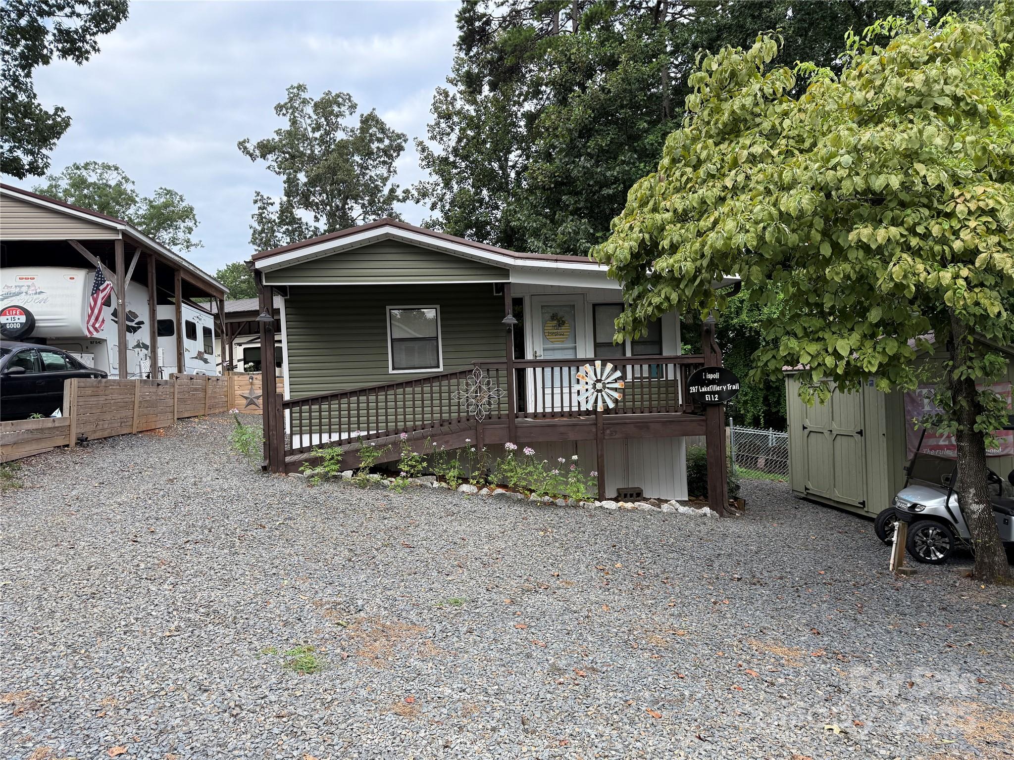 Plenty of space inside and out with this great unit. Double lots, Updated 1990 Park Model. Kitchen and bath were redone two years ago. Beautiful granite counters, new cabinets with plenty of storage.  Refrigerator, stove and washer/dryer 2 years old and to remain. Metal Roof is 6 years old. HVAC is 5 years old. Queen in primary and twin in secondary bedroom. 2 storage buildings, new concrete block wall, fenced back yard for your dogs and a doggy door. The screen porch out back is awesome.  Incredible view of the water in the winter and a peek-a-boo in the summer. Who wants to make this great unit their "Happy Place"? 2024 Ez-Go Valor golf cart available for $9k. All buyers must be with a realtor to gain entrance to the community.