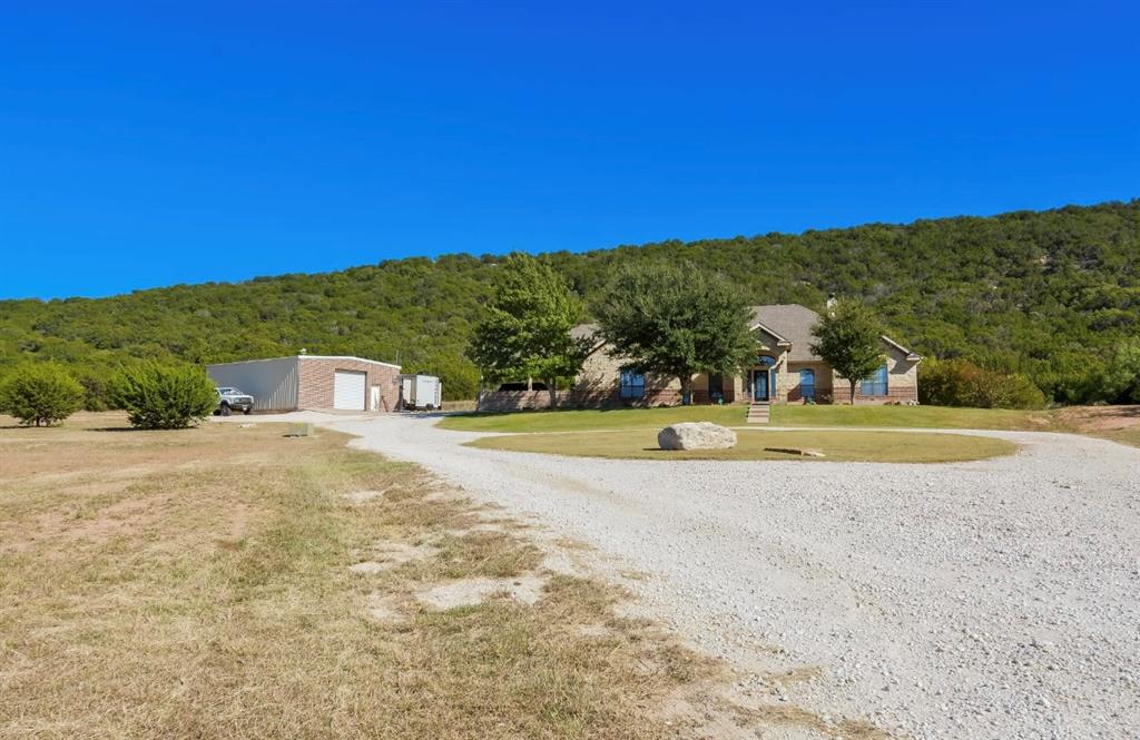 View of dirt / gravel road featuring a wooded view
